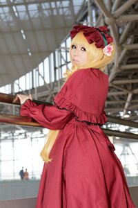 Rating: Safe Score: 0 Tags: 1girl blonde_hair blue_eyes blurry blurry_background blurry_foreground building capelet depth_of_field dress flower long_sleeves looking_at_viewer looking_back outdoors railing red_dress shinku solo standing User: admin