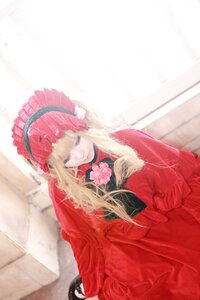 Rating: Safe Score: 0 Tags: 1girl bangs blonde_hair blurry blurry_background bonnet closed_mouth depth_of_field dress flower long_hair long_sleeves looking_at_viewer red_capelet red_dress rose shinku sitting solo User: admin