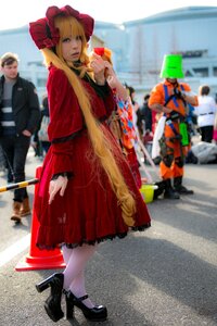 Rating: Safe Score: 0 Tags: 1girl black_footwear blonde_hair blue_eyes blurry blurry_background bonnet depth_of_field dress flower high_heels long_hair looking_at_viewer multiple_boys photo red_dress shinku solo solo_focus standing User: admin