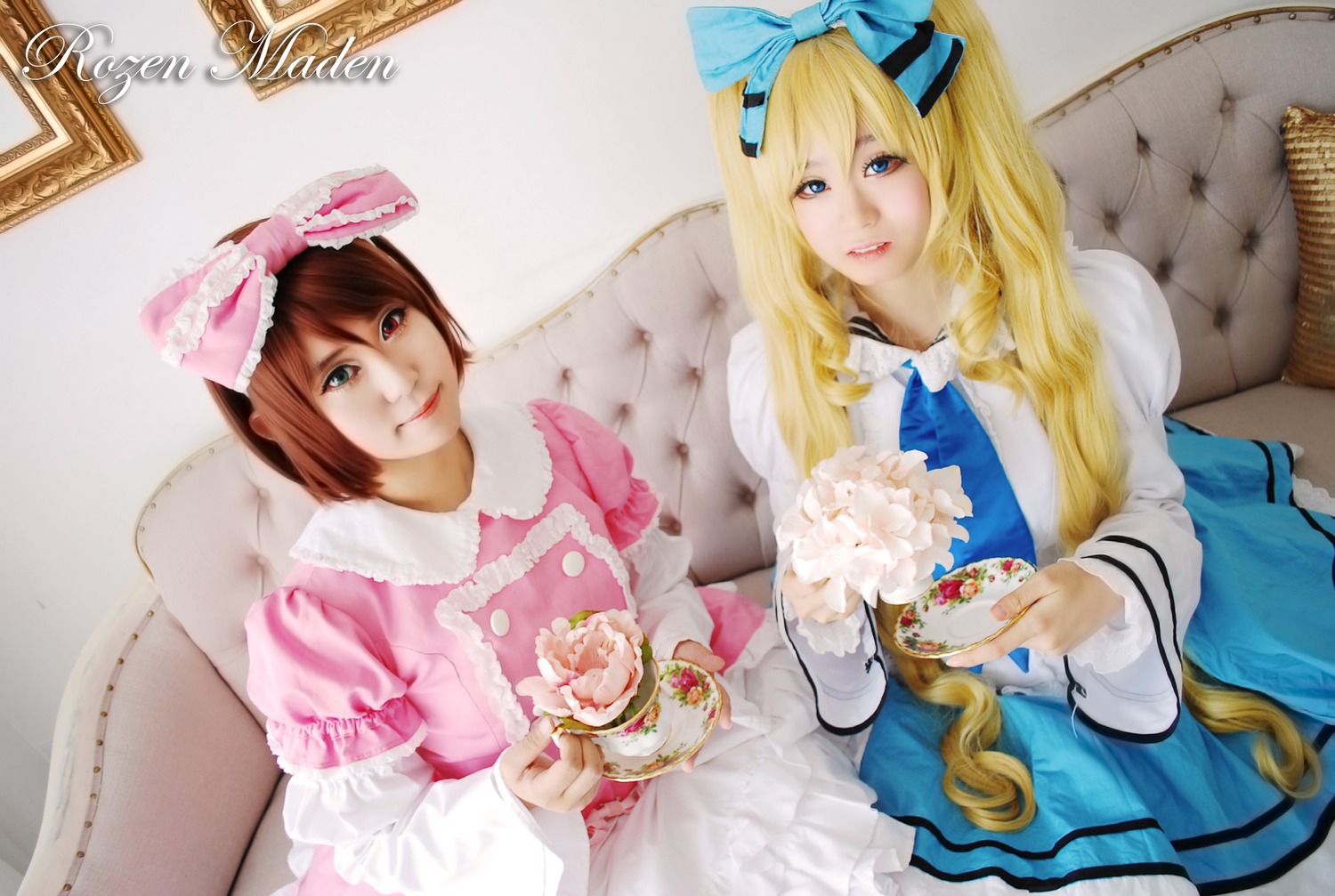 2girls blonde_hair blue_eyes bow brown_hair couch crossdressing cup dress food hair_bow hair_ribbon lips long_hair multiple_cosplay multiple_girls ribbon short_hair tagme teacup