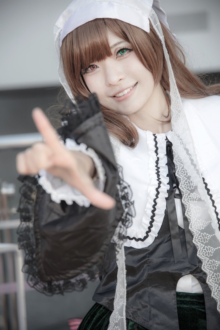 1girl blurry blurry_background blurry_foreground brown_hair depth_of_field dress green_eyes grin heterochromia lips lolita_fashion long_hair looking_at_viewer outstretched_arm photo pointing pointing_at_viewer red_eyes smile solo suiseiseki