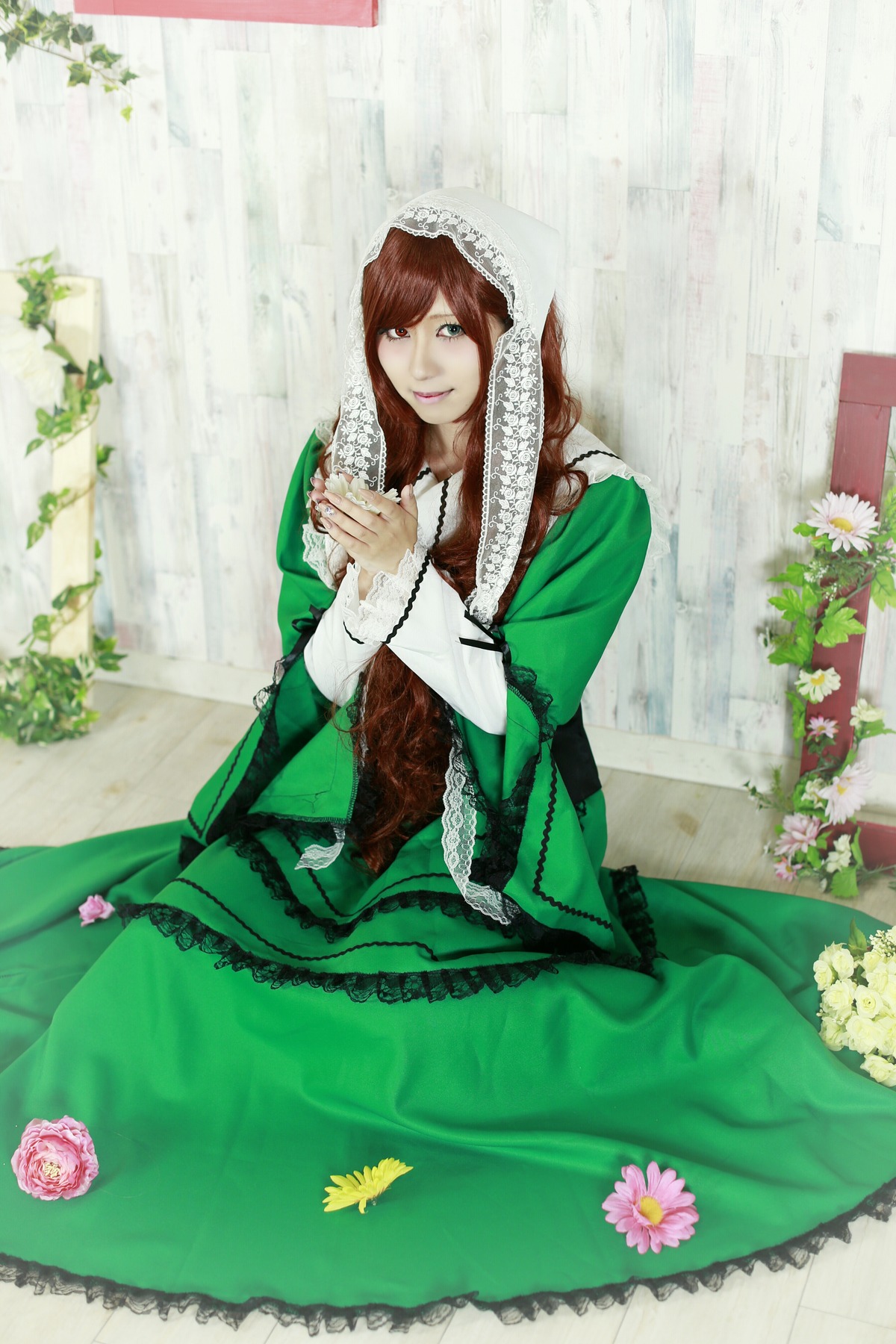 1girl brown_hair dress flower green_dress green_eyes long_hair looking_at_viewer sitting solo suiseiseki