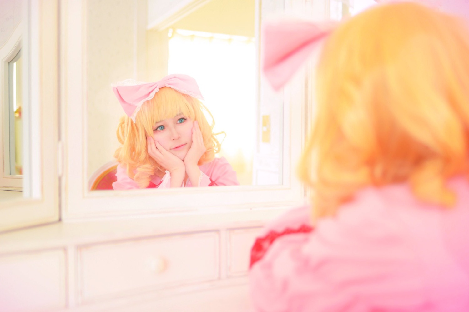 1girl bangs blonde_hair blue_eyes blurry blurry_background blurry_foreground bow depth_of_field dress hand_on_own_cheek hands_on_own_face hinaichigo indoors mirror motion_blur photo reflection solo