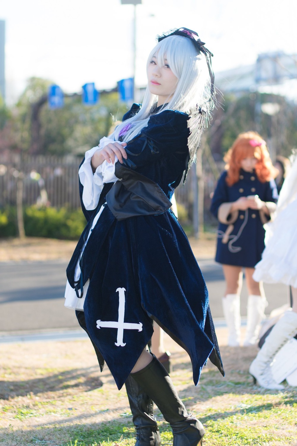 bag black_dress blurry blurry_background blurry_foreground boots depth_of_field dress long_sleeves multiple_girls outdoors photo photo_background solo standing suigintou