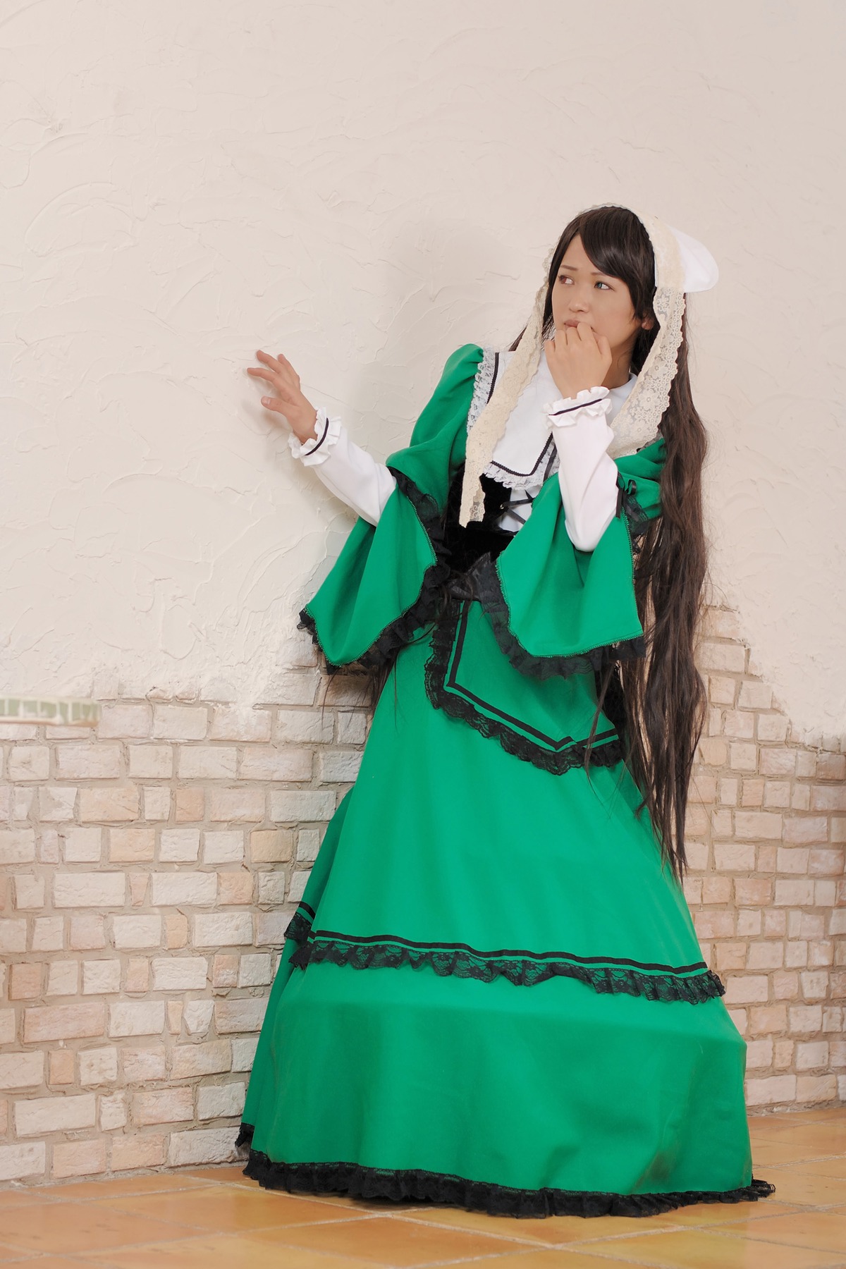 1girl against_wall black_hair brick_wall dress green_dress long_sleeves solo standing suiseiseki