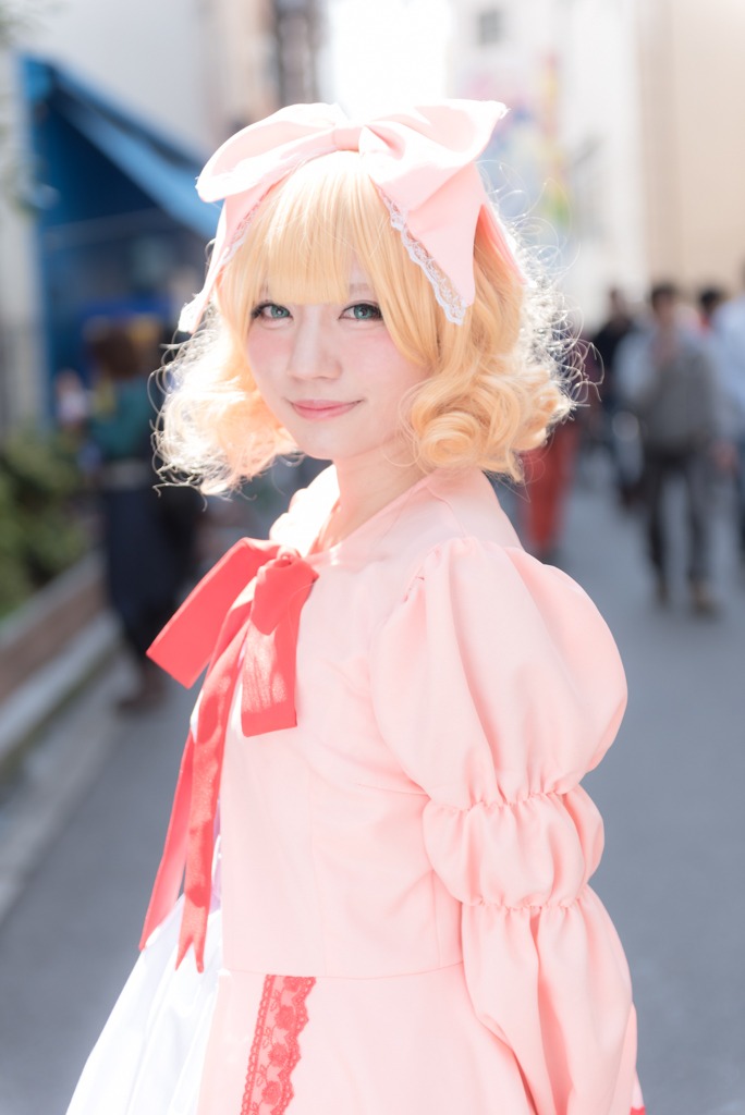 1girl artist_name blonde_hair blue_eyes blurry blurry_background blurry_foreground bow day depth_of_field dress hair_bow hinaichigo lips looking_at_viewer photo ribbon see-through short_hair smile solo striped upper_body vertical_stripes watermark