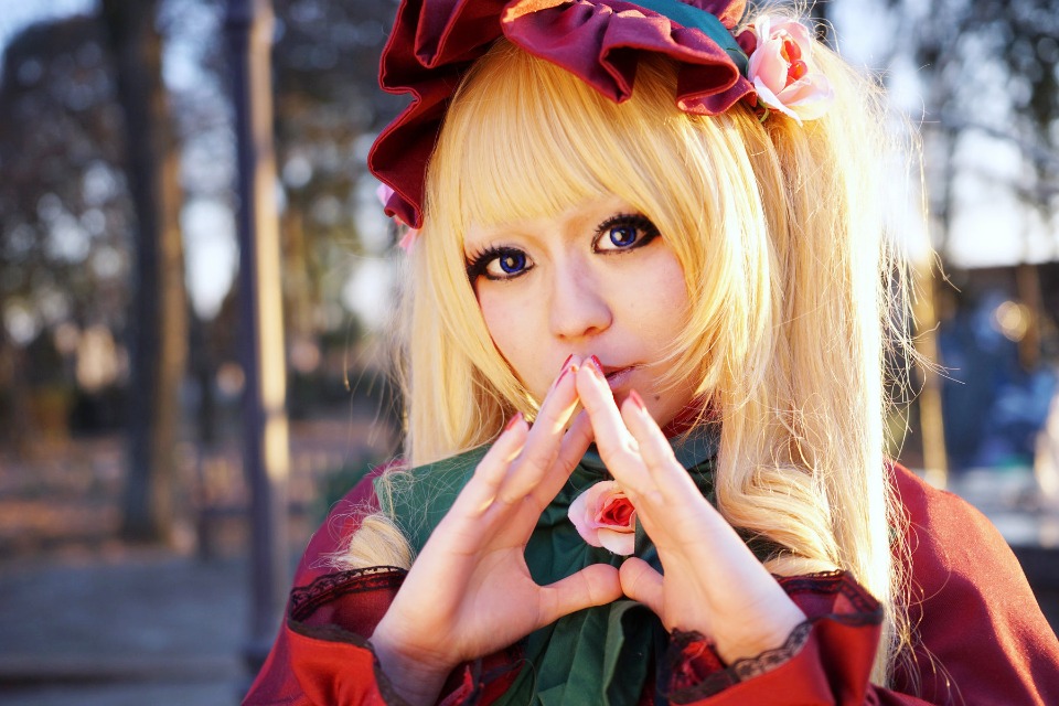 1girl bangs blonde_hair blue_eyes blurry blurry_background blurry_foreground bow city depth_of_field hat long_hair looking_at_viewer photo realistic shinku solo upper_body
