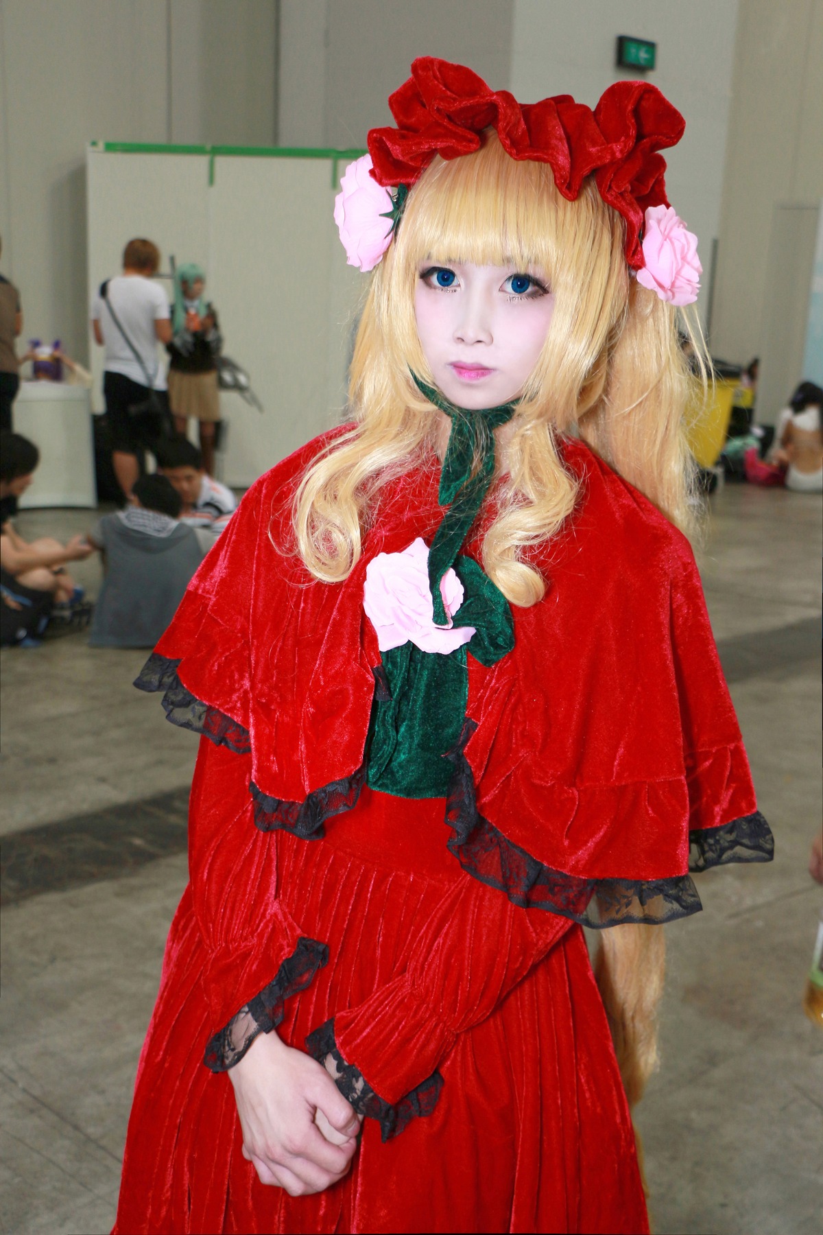 1girl blonde_hair blue_eyes blurry blurry_background depth_of_field dress flower hair_ornament lips long_hair looking_at_viewer multiple_boys photo realistic red_dress shinku solo solo_focus
