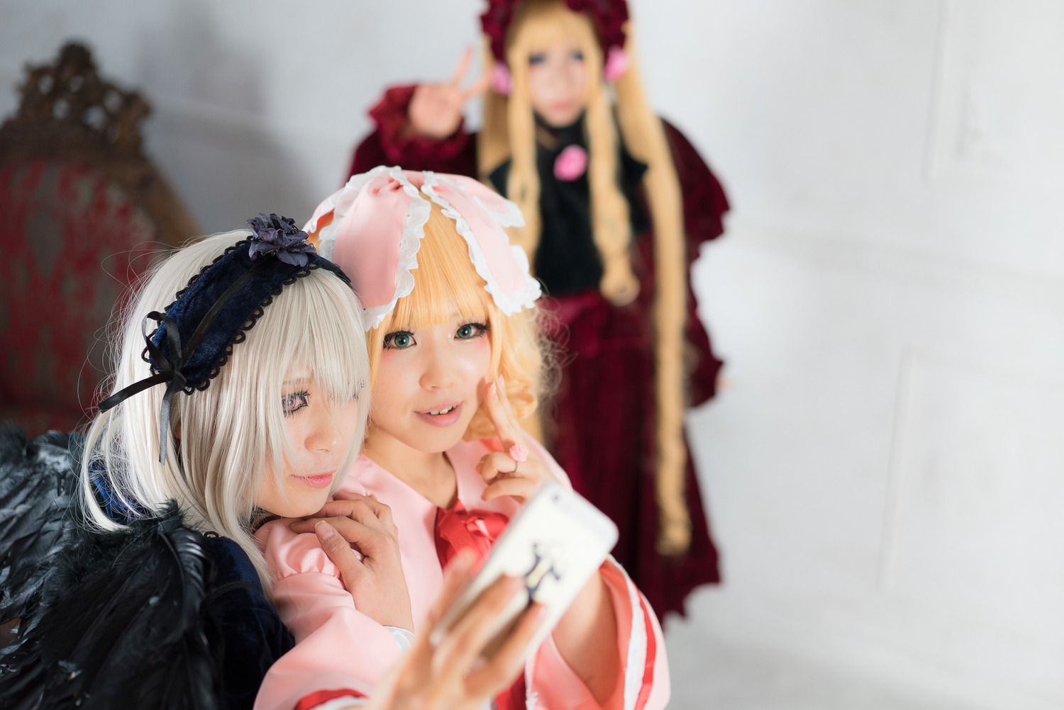 3d black_wings blonde_hair blurry blurry_background blurry_foreground depth_of_field hairband looking_at_viewer multiple_cosplay multiple_girls photo realistic short_hair sisters suigintou tagme wings