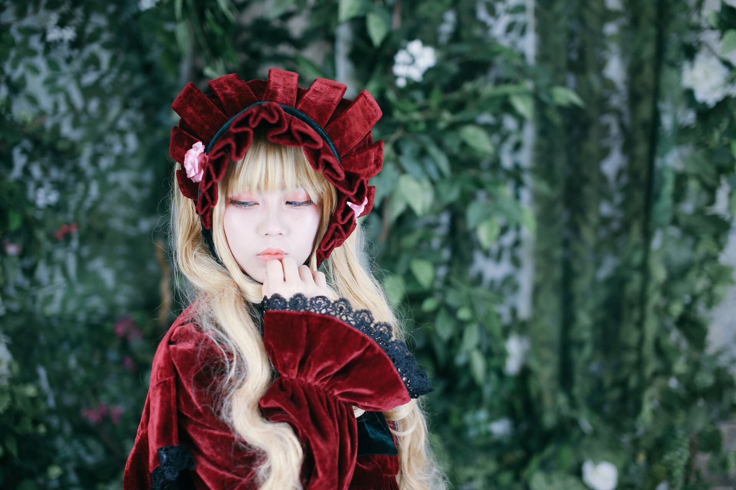 1girl blonde_hair blue_eyes blurry blurry_background blurry_foreground bonnet depth_of_field dress flower hairband long_hair long_sleeves looking_at_viewer red_dress rose shinku solo