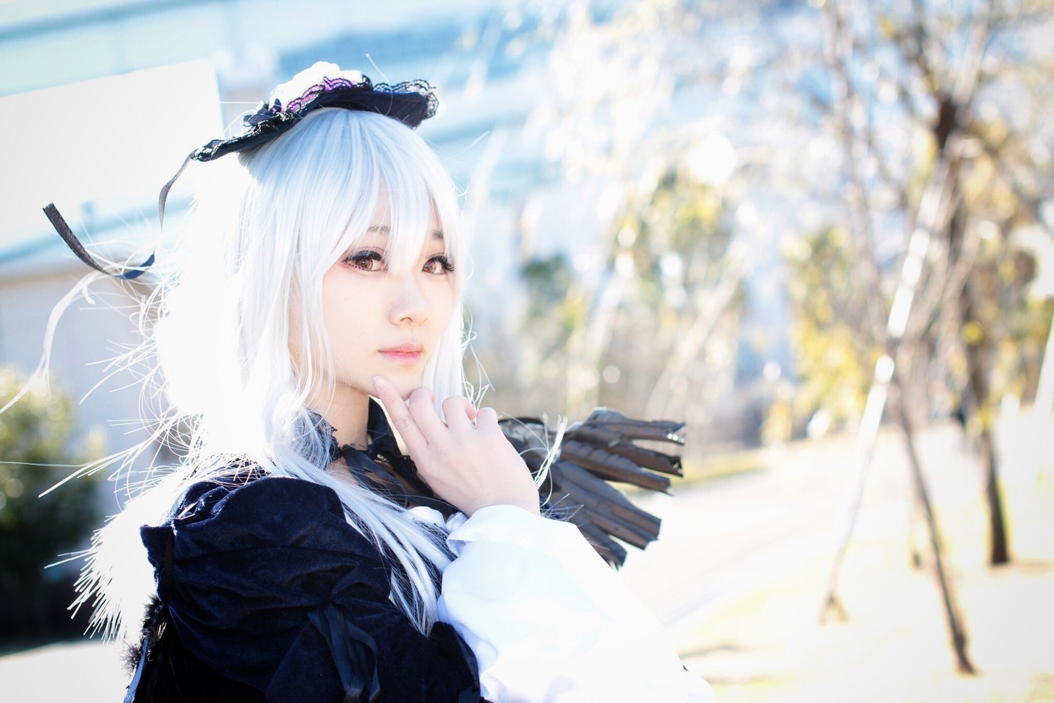 1girl 3d black_dress black_ribbon blurry blurry_background blurry_foreground closed_mouth depth_of_field dress frills lips long_hair long_sleeves photo red_eyes ribbon solo suigintou upper_body white_hair wings