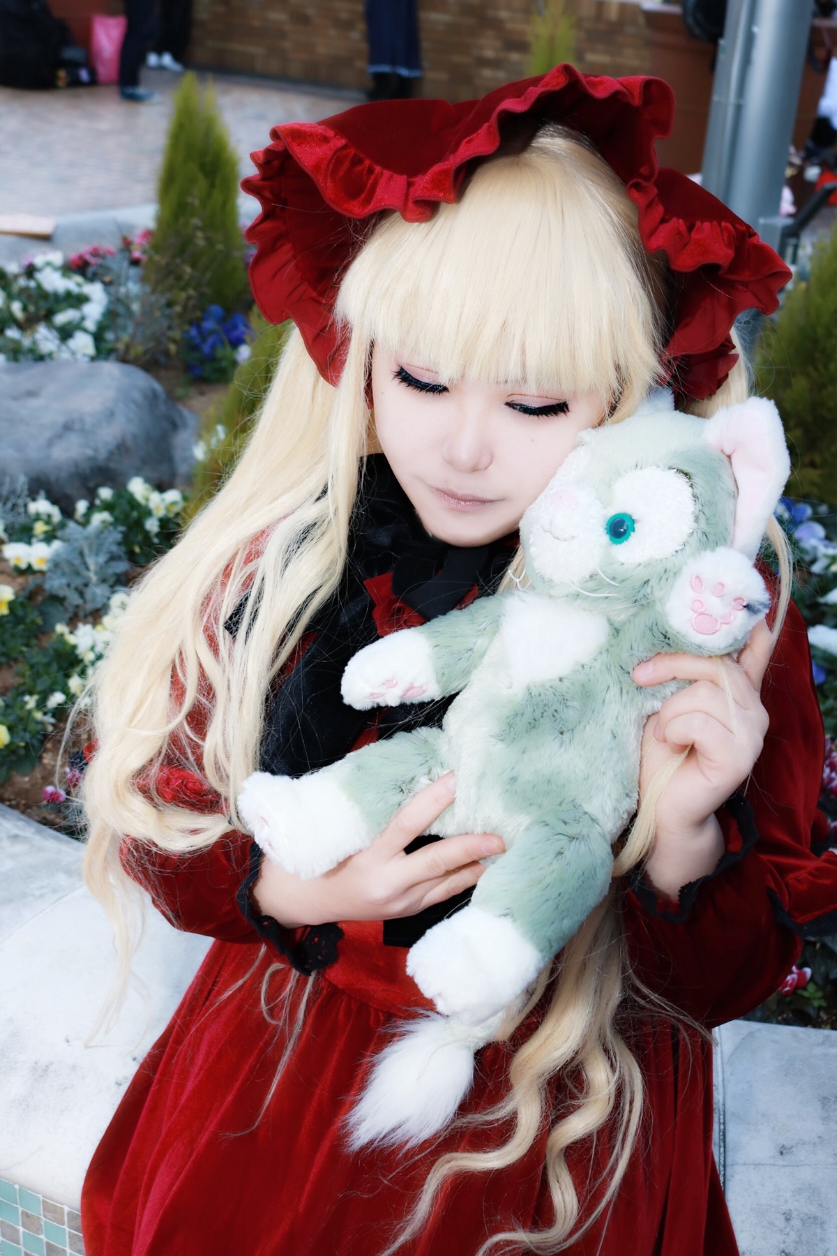 1girl bangs blonde_hair blurry blurry_background bow building closed_eyes depth_of_field dress holding lace long_hair long_sleeves outdoors photo red_dress shinku solo