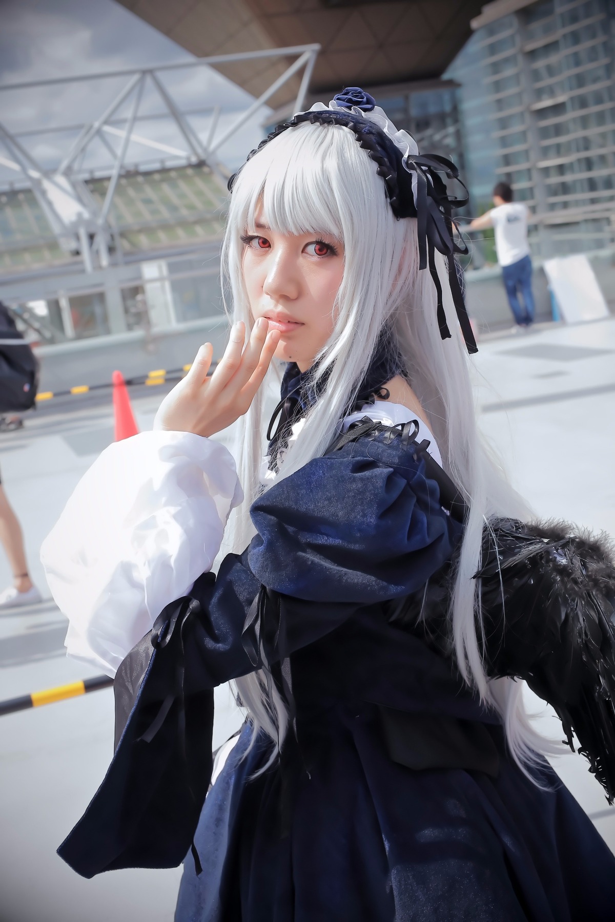 1girl 3d black_dress blurry blurry_background city depth_of_field dress gothic_lolita hairband long_hair long_sleeves looking_at_viewer photo red_eyes ribbon solo suigintou white_hair