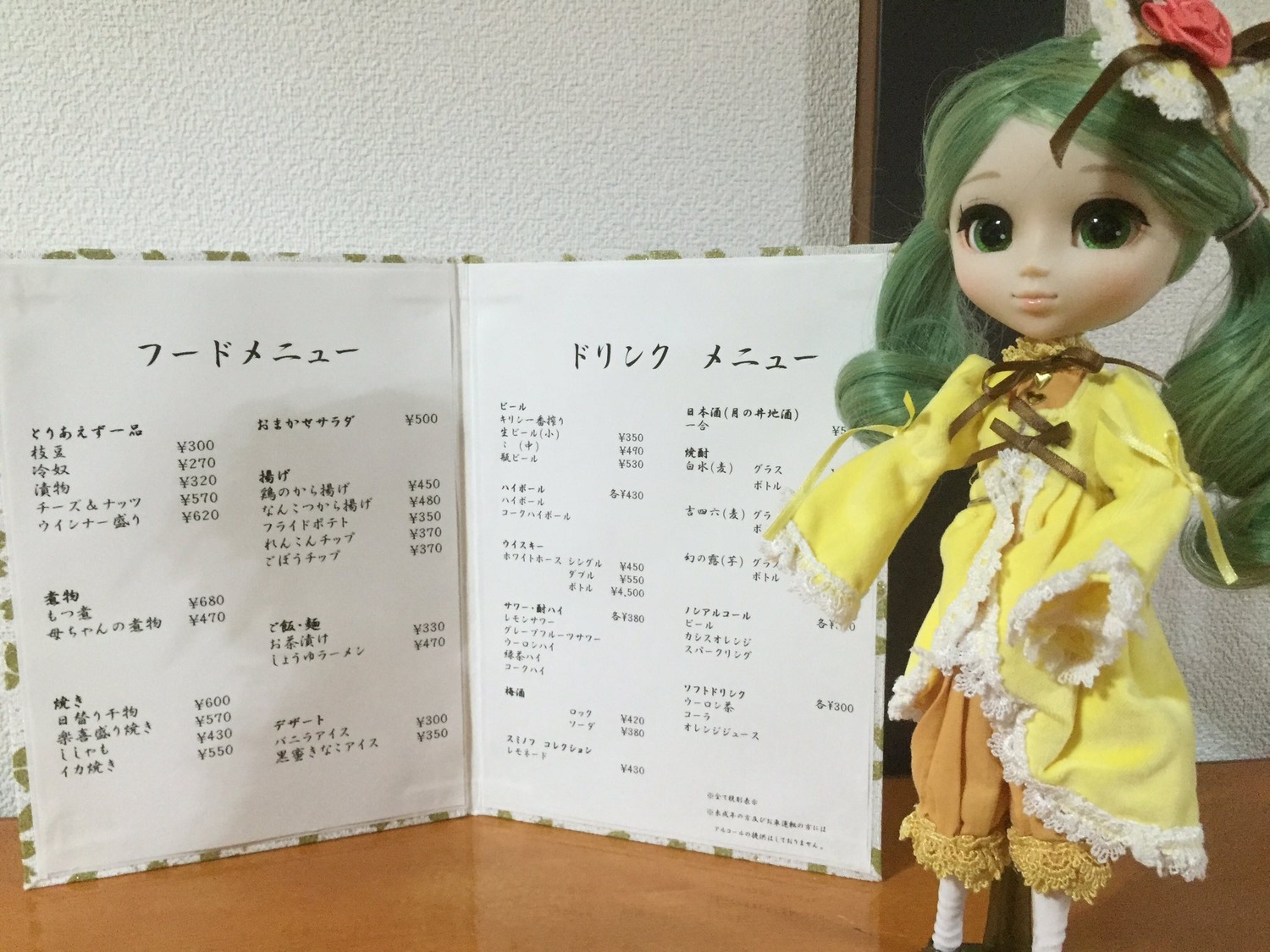 1girl bloomers calendar_(medium) doll dress drill_hair flower frills green_eyes green_hair hair_flower hair_ornament kanaria ribbon sitting solo text_focus underwear yellow_dress