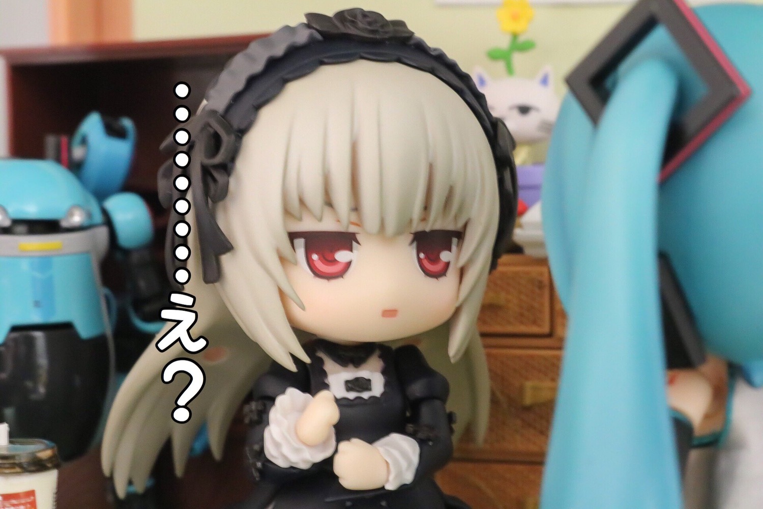 2girls 3d black_dress blurry blurry_background blurry_foreground depth_of_field doll dress figure flower hairband indoors lolita_hairband long_hair long_sleeves motion_blur multiple_girls photo photo_background red_eyes solo suigintou wings