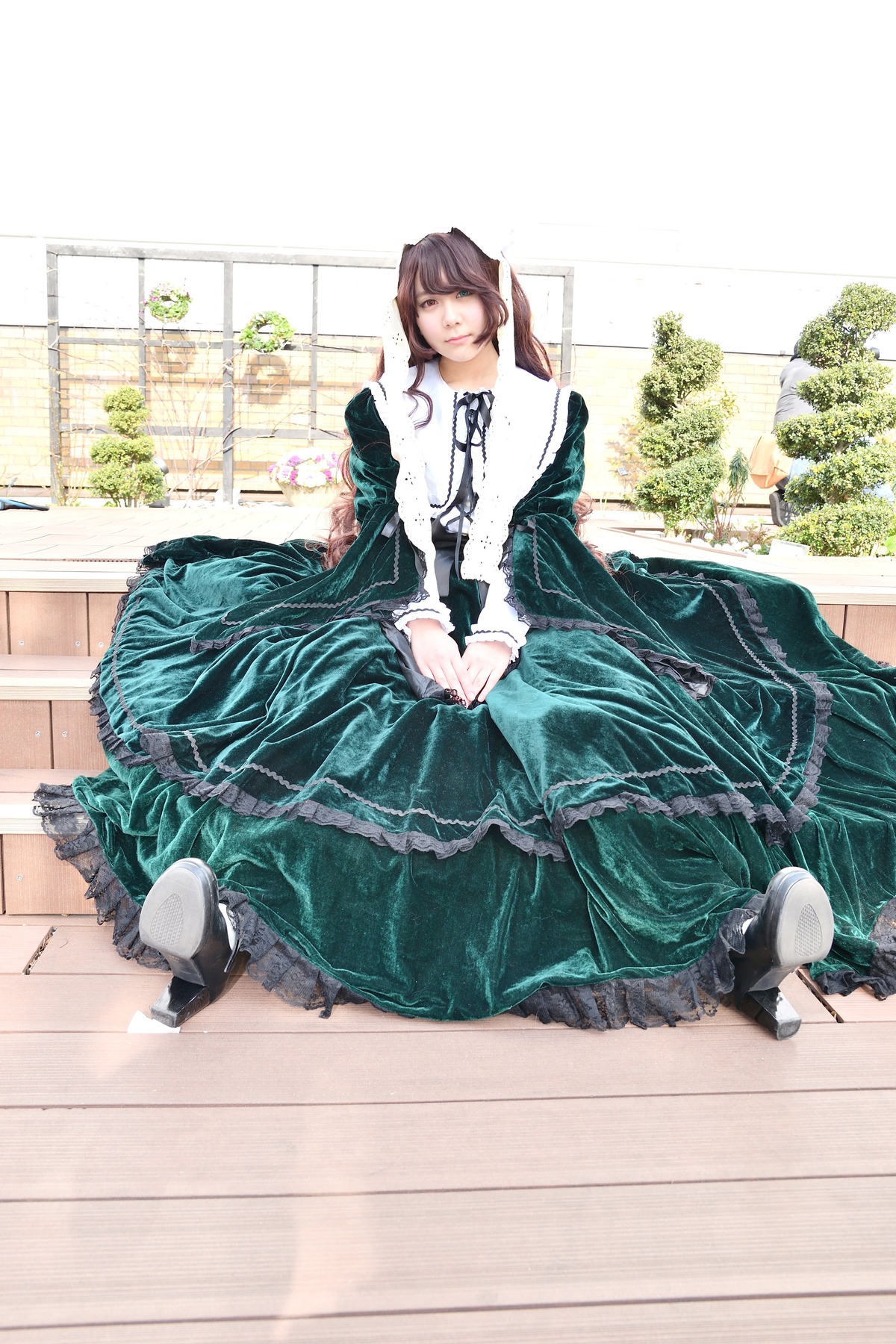 1girl brown_hair dress green_dress long_hair long_sleeves sitting solo suiseiseki