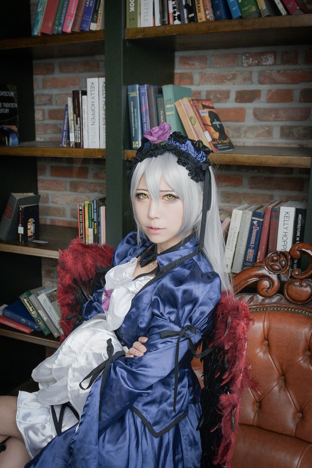 1girl book book_stack bookshelf dress flower green_eyes hair_flower hair_ornament library long_hair looking_at_viewer rose sitting solo suigintou yellow_eyes