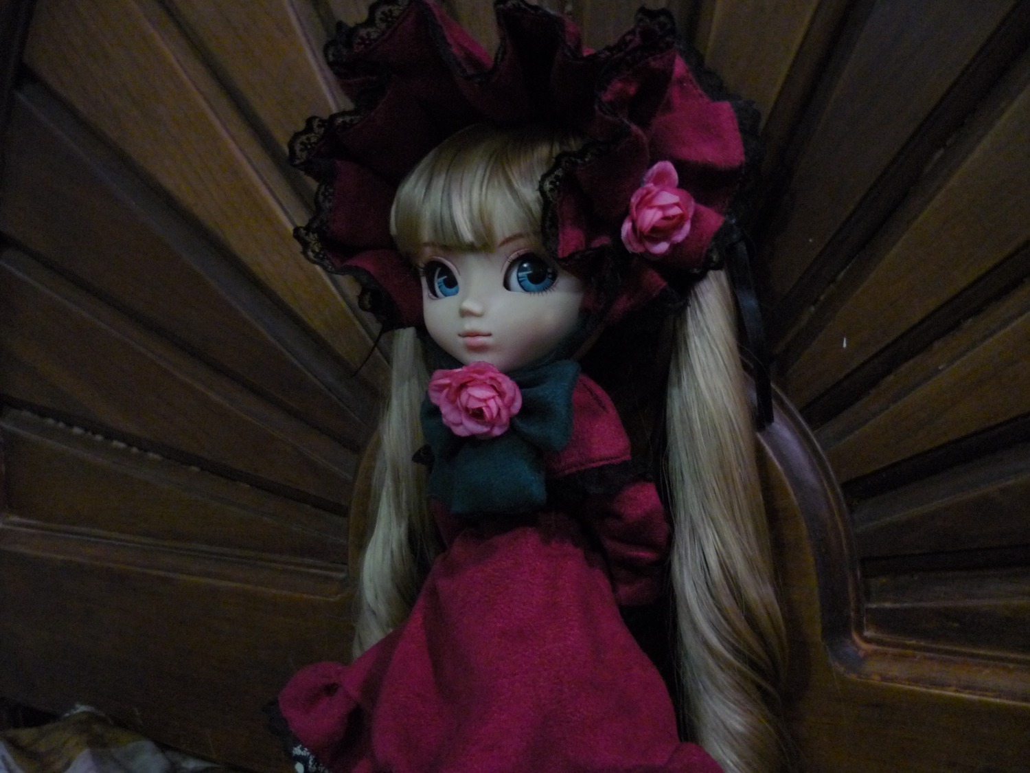 1girl blonde_hair blue_eyes bonnet bow doll dress flower long_hair looking_at_viewer photo pink_flower pink_rose red_dress red_flower red_rose rose shinku sitting solo very_long_hair