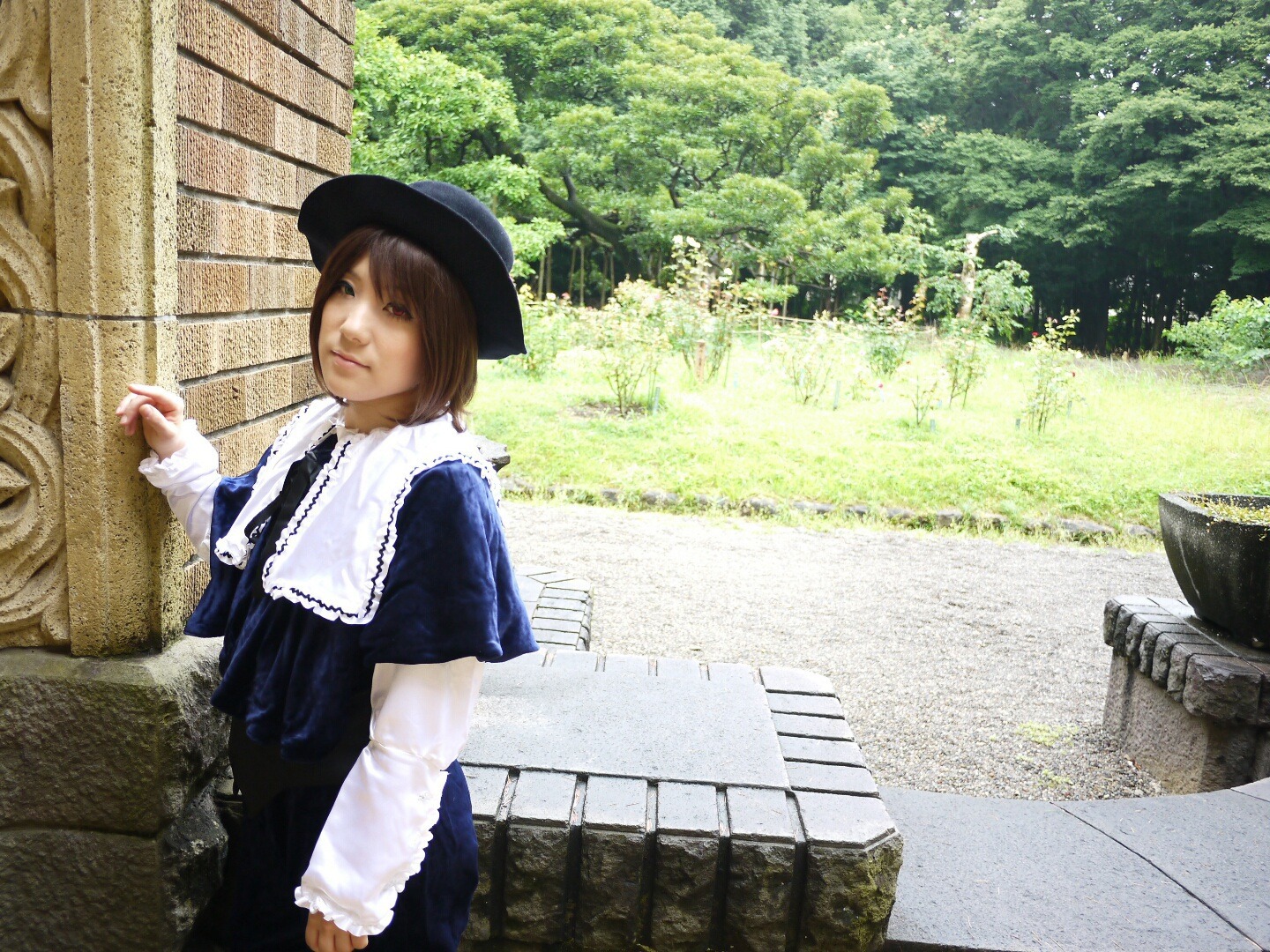 1girl brown_eyes brown_hair building capelet city cup day dress hat long_sleeves outdoors photo_background realistic short_hair solo souseiseki