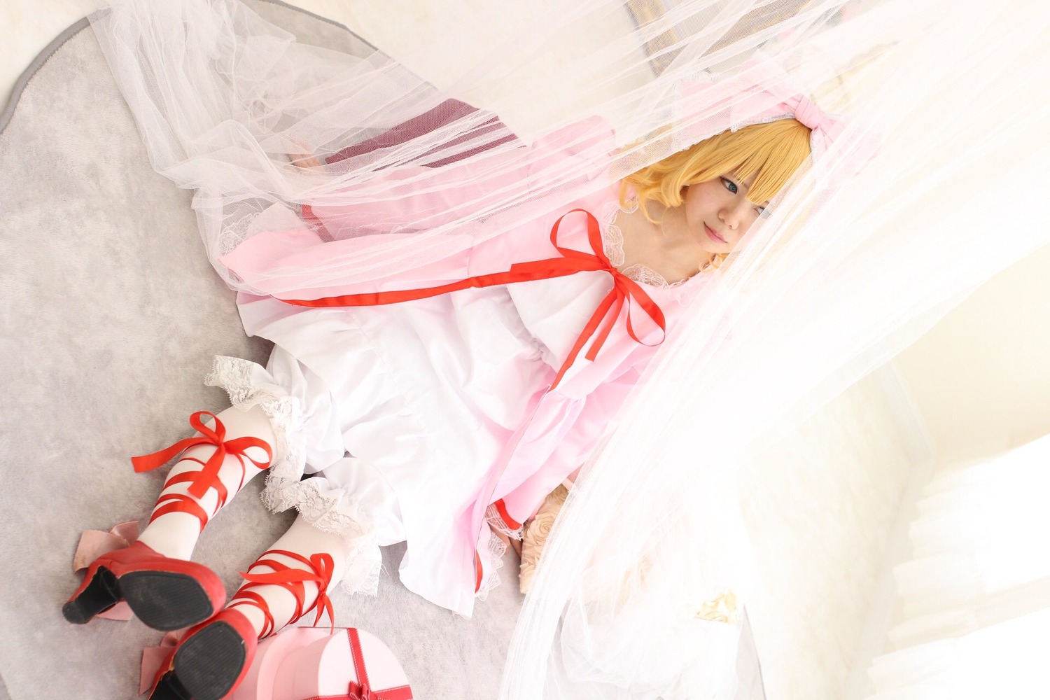 1girl blonde_hair blue_eyes dress hinaichigo hood red_ribbon ribbon sandals short_hair sitting solo white_dress