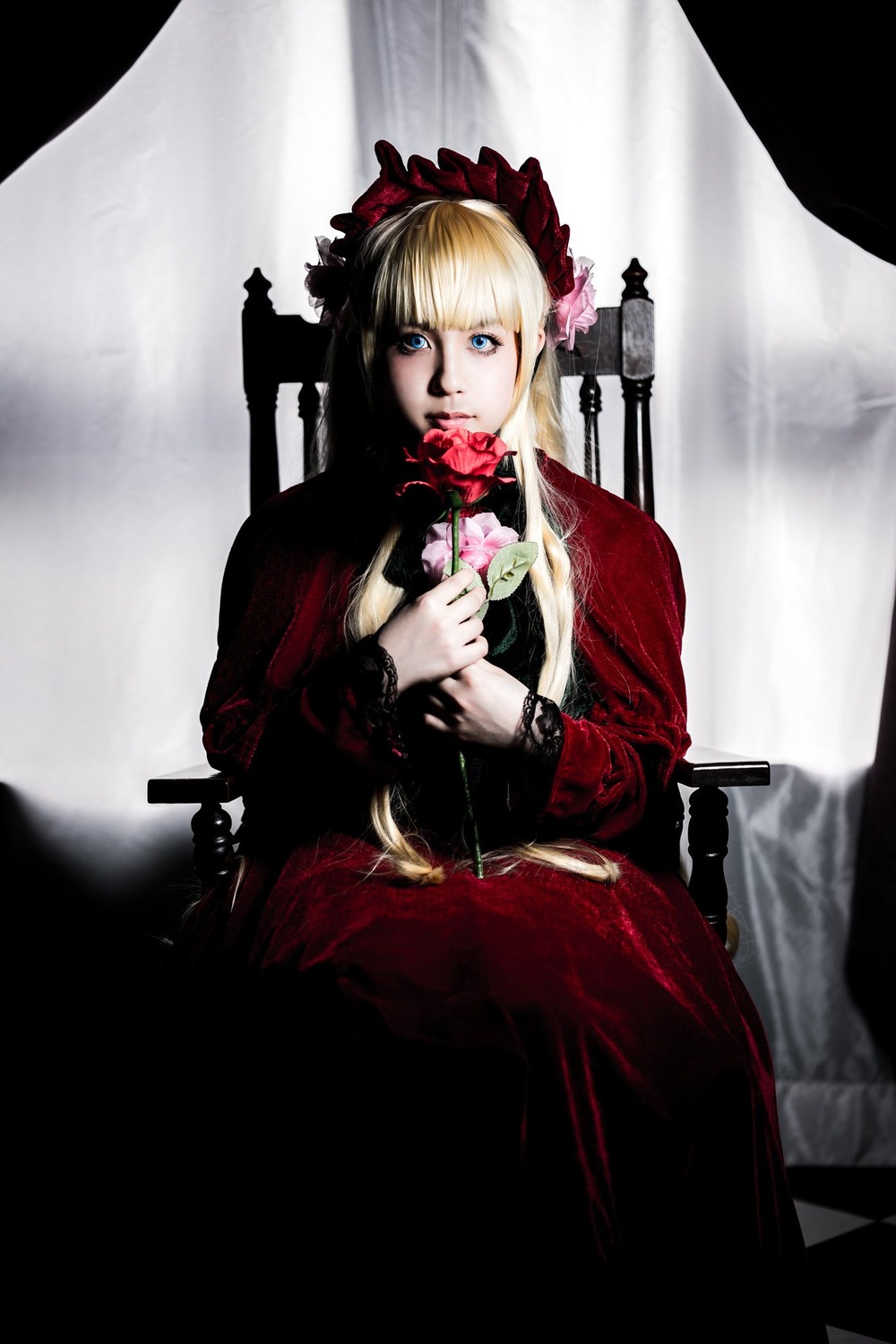 1girl bangs blonde_hair blue_eyes bonnet curtains dress flower long_sleeves looking_at_viewer red_dress rose shinku sitting solo