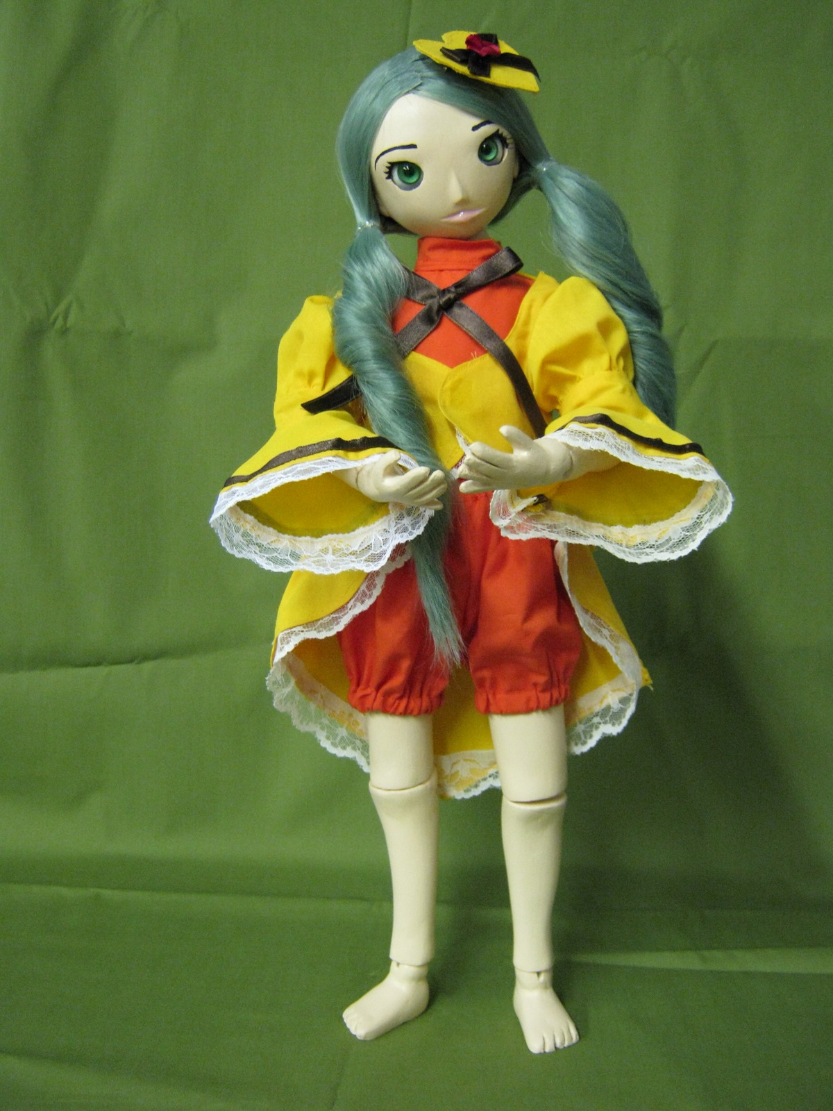 1girl capelet doll full_body green_background green_eyes hat kanaria long_hair long_sleeves looking_at_viewer solo standing
