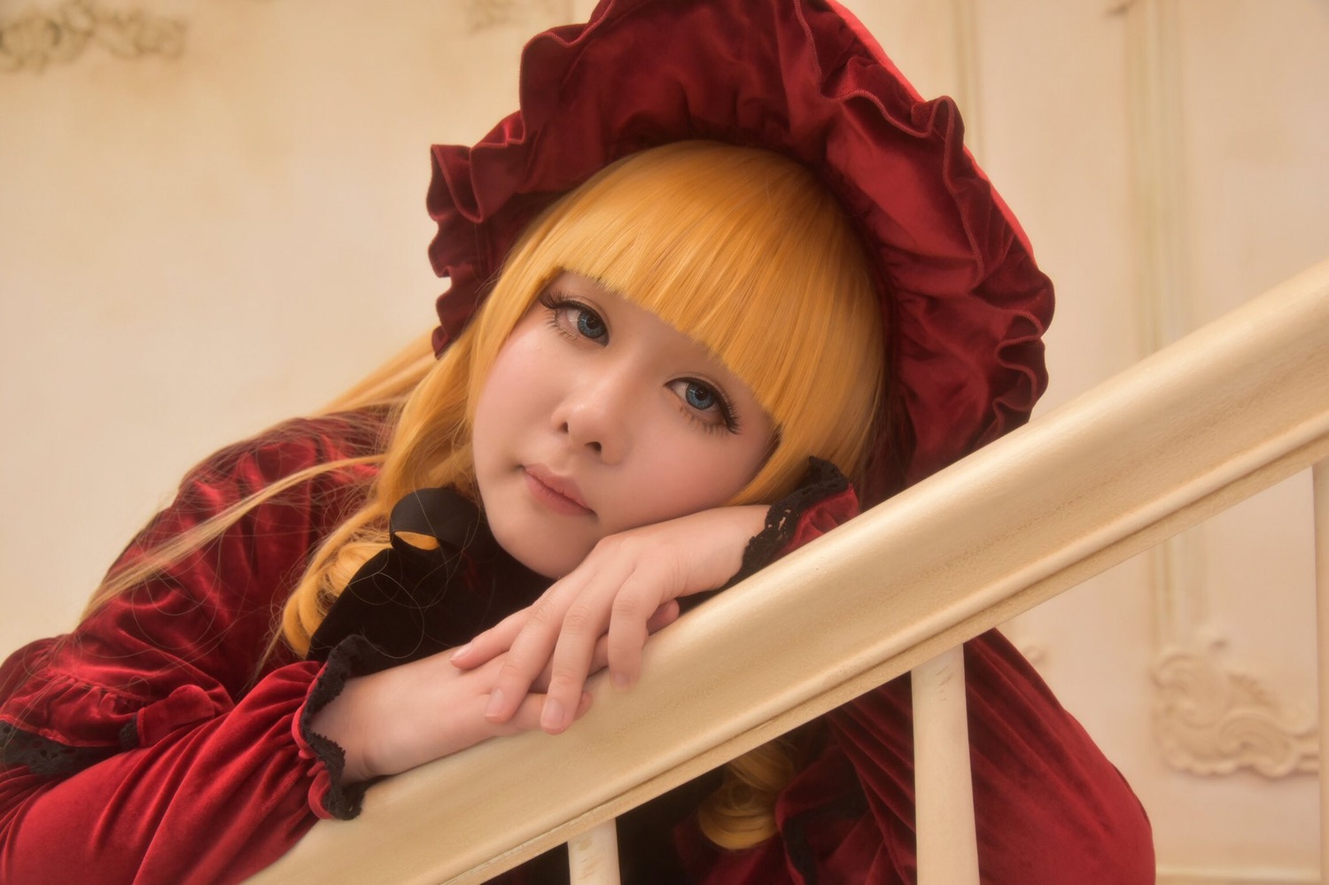 1girl bangs blonde_hair blue_eyes blunt_bangs bonnet head_rest lips long_hair long_sleeves looking_at_viewer realistic red_dress shinku solo