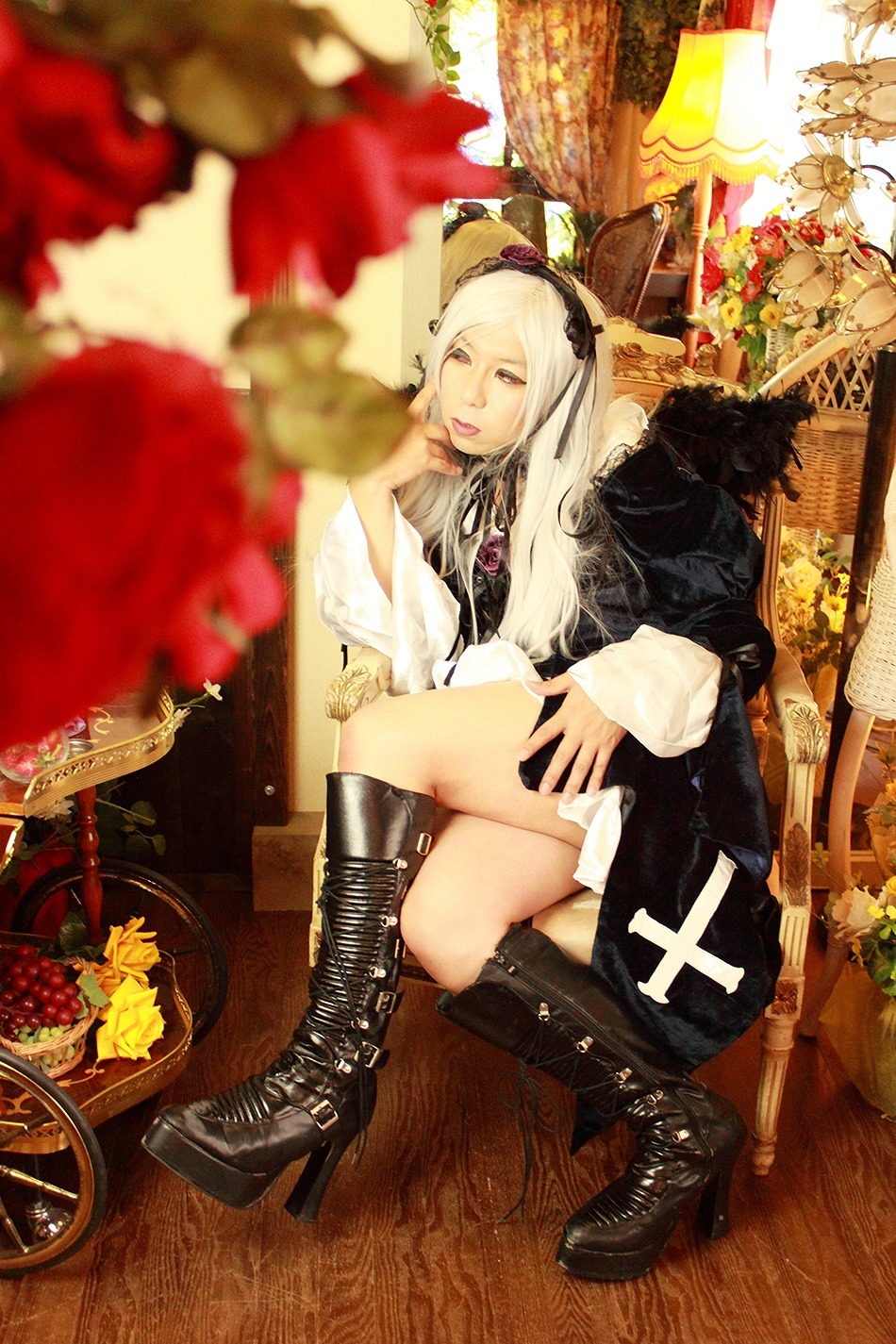 1girl black_footwear blurry blurry_foreground boots cross-laced_footwear depth_of_field dress flower food high_heel_boots high_heels lace-up_boots long_hair sitting solo suigintou white_hair