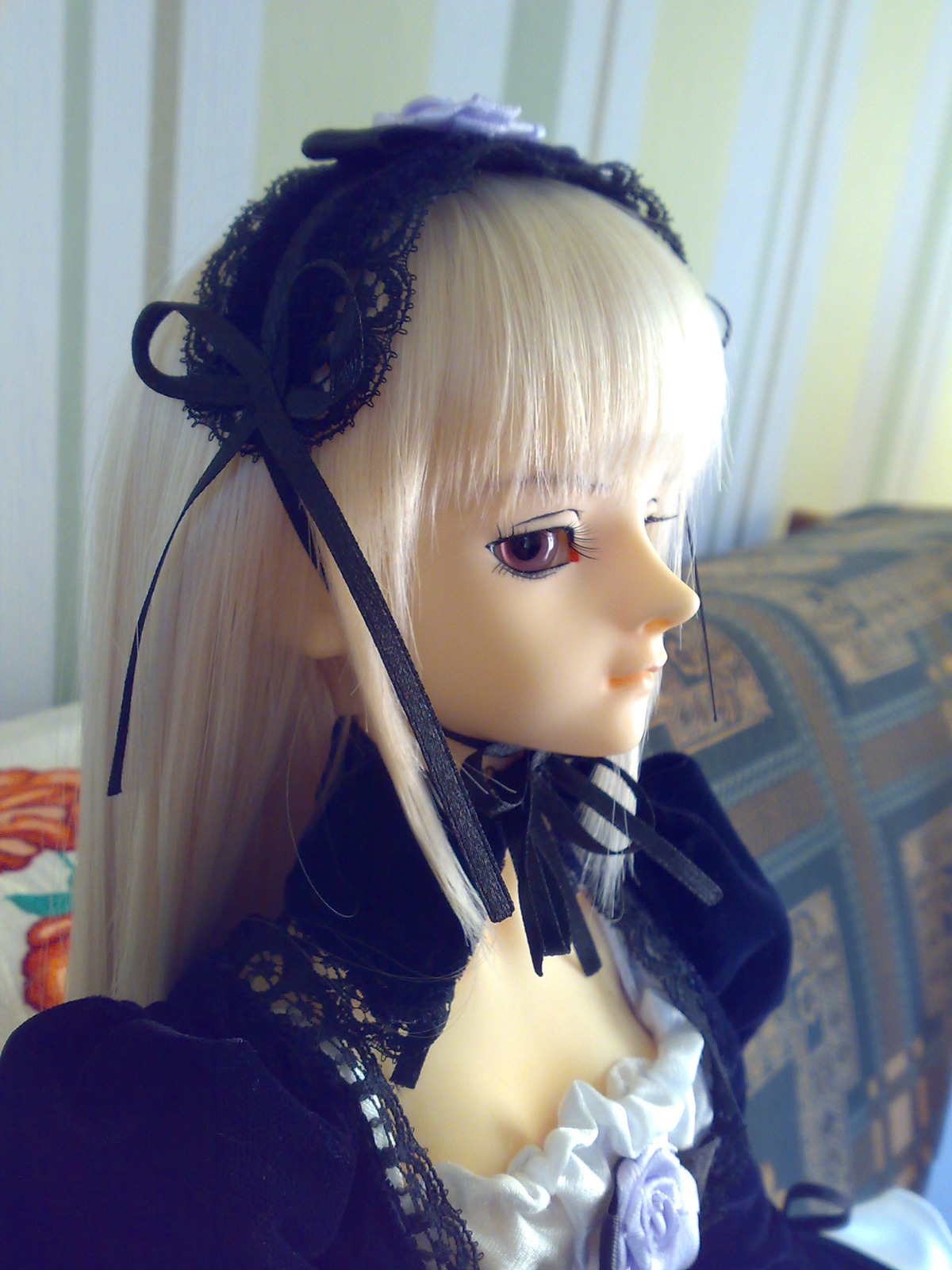 1girl 3d bangs blurry closed_mouth depth_of_field doll dress flower frills gothic_lolita hairband lace lips lolita_fashion long_hair long_sleeves photo profile ribbon solo suigintou upper_body white_hair