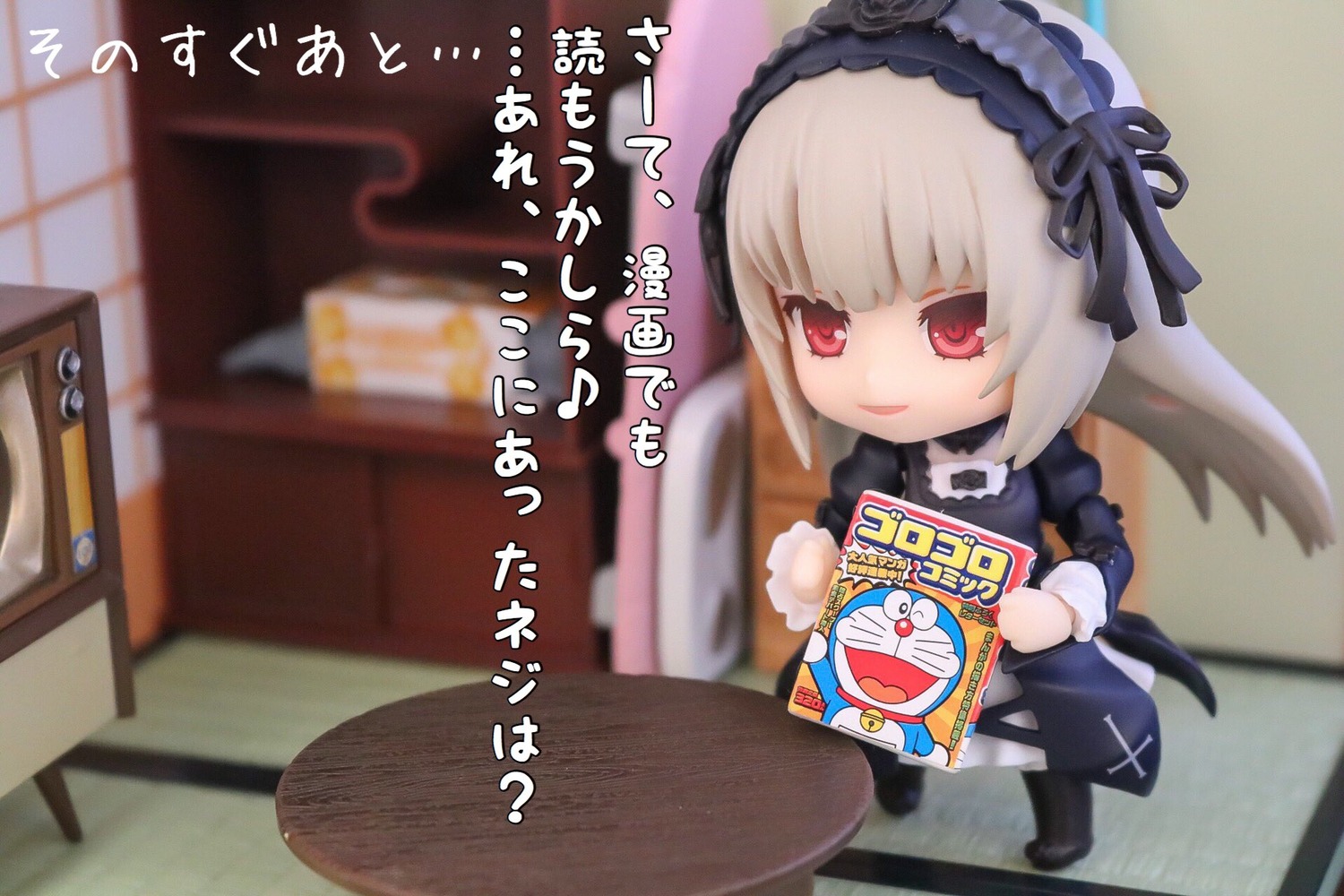 1girl blurry blurry_background chibi depth_of_field doll dress figure hairband juliet_sleeves lolita_fashion long_hair long_sleeves photo red_eyes smile solo suigintou table wings