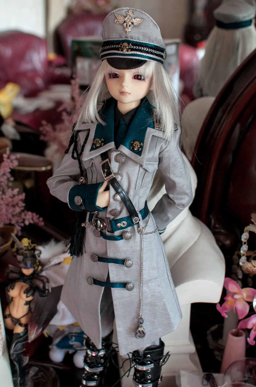 1girl belt blurry blurry_background blurry_foreground coat depth_of_field doll gloves gun hat long_hair looking_at_viewer necktie photo red_eyes solo suigintou uniform weapon white_hair wings