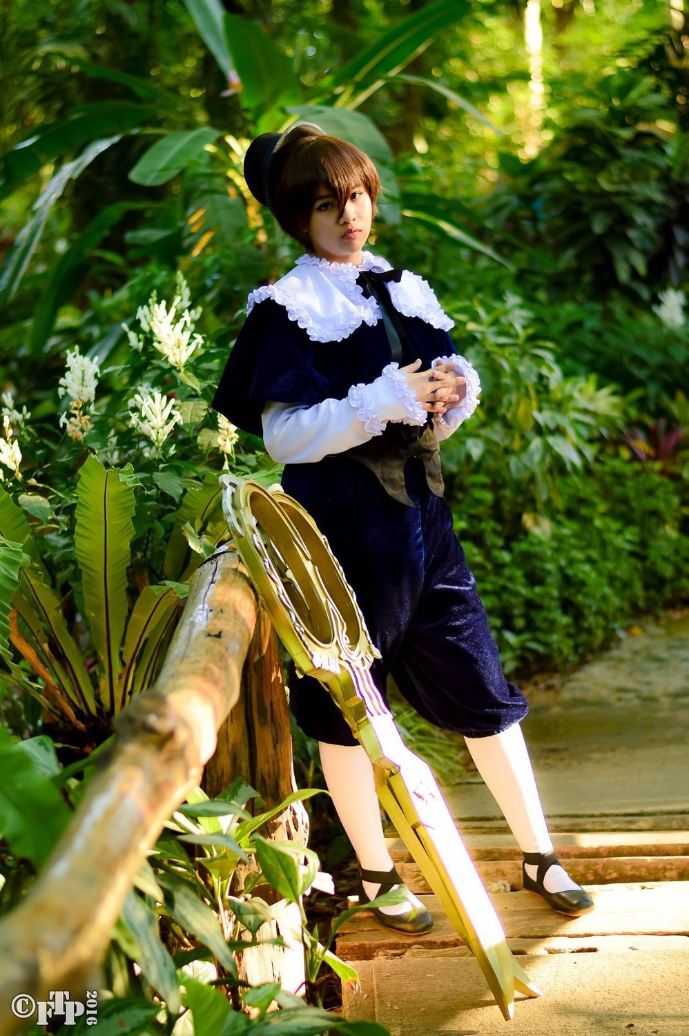 1girl blurry brown_hair day depth_of_field dress hair_bun long_sleeves outdoors plant sitting solo souseiseki