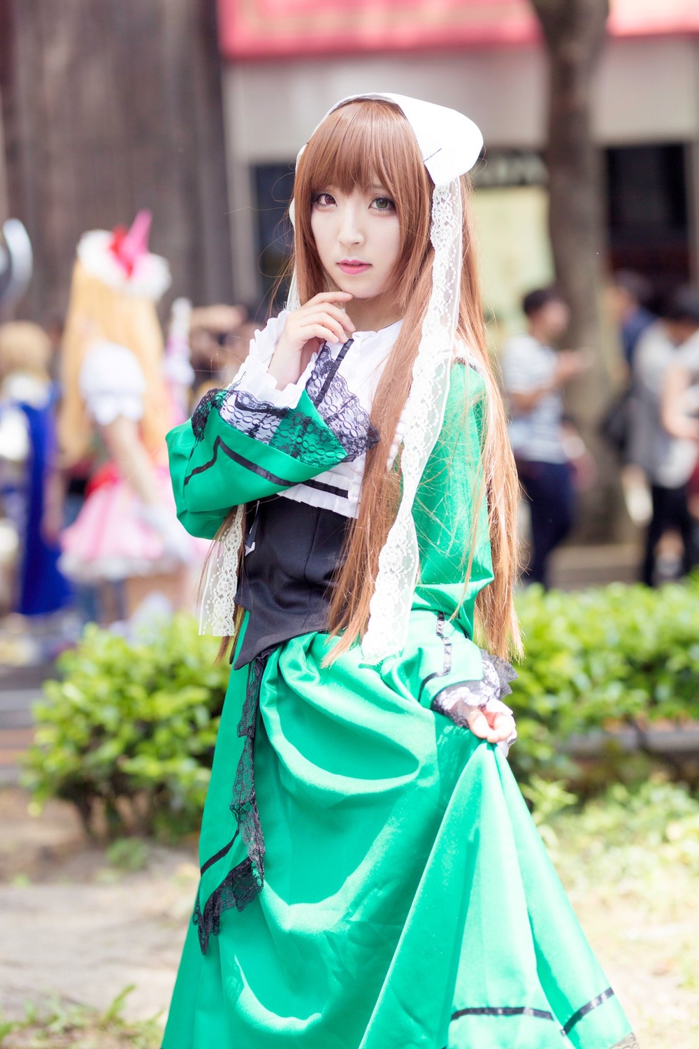 1girl 3d blurry blurry_background blurry_foreground brown_hair depth_of_field dress figure green_dress lips looking_at_viewer photo solo solo_focus suiseiseki