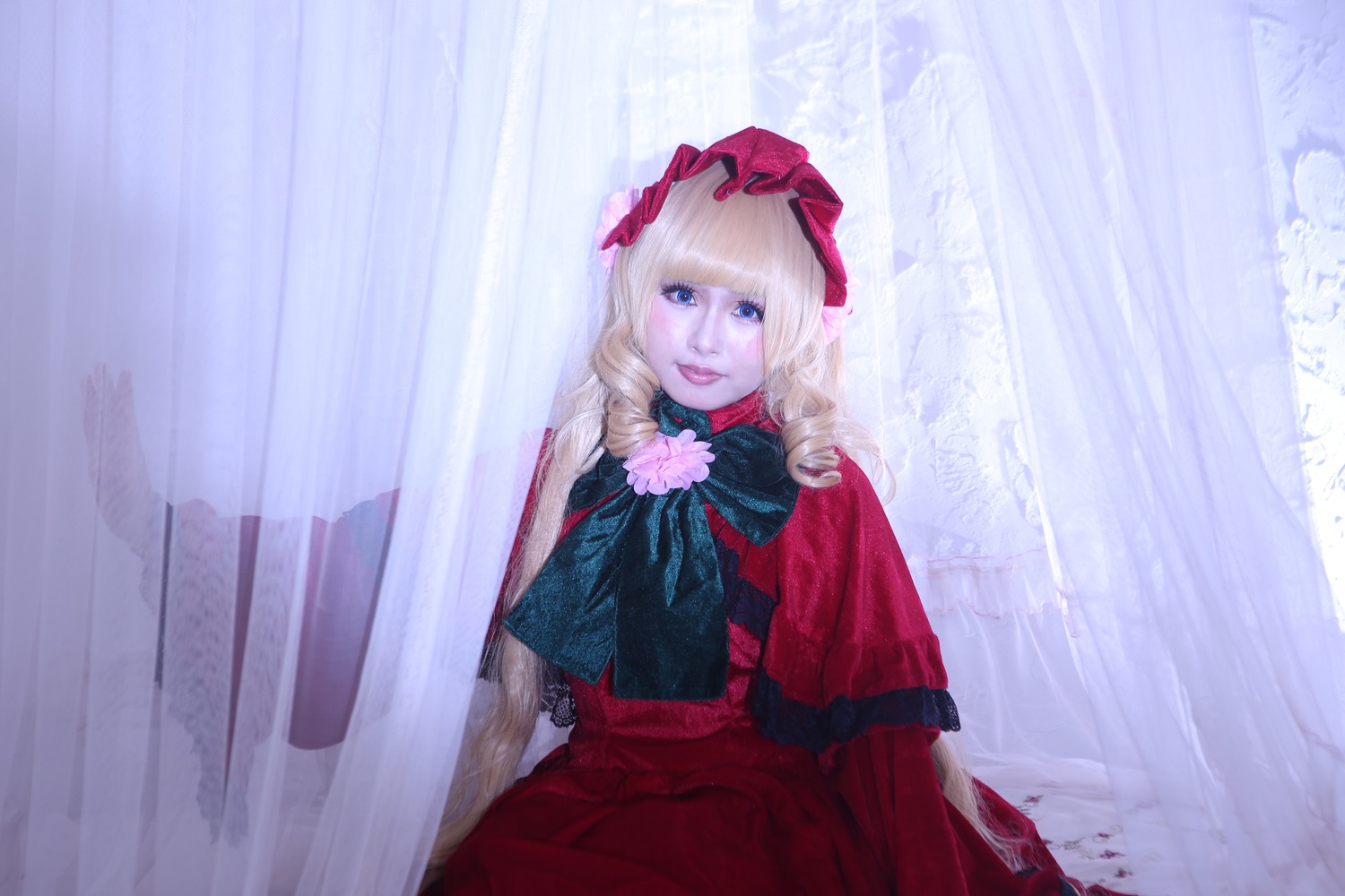 1girl bangs blonde_hair blue_eyes bow capelet curtains dress flower lips long_hair long_sleeves looking_at_viewer red_dress rose shinku sitting solo