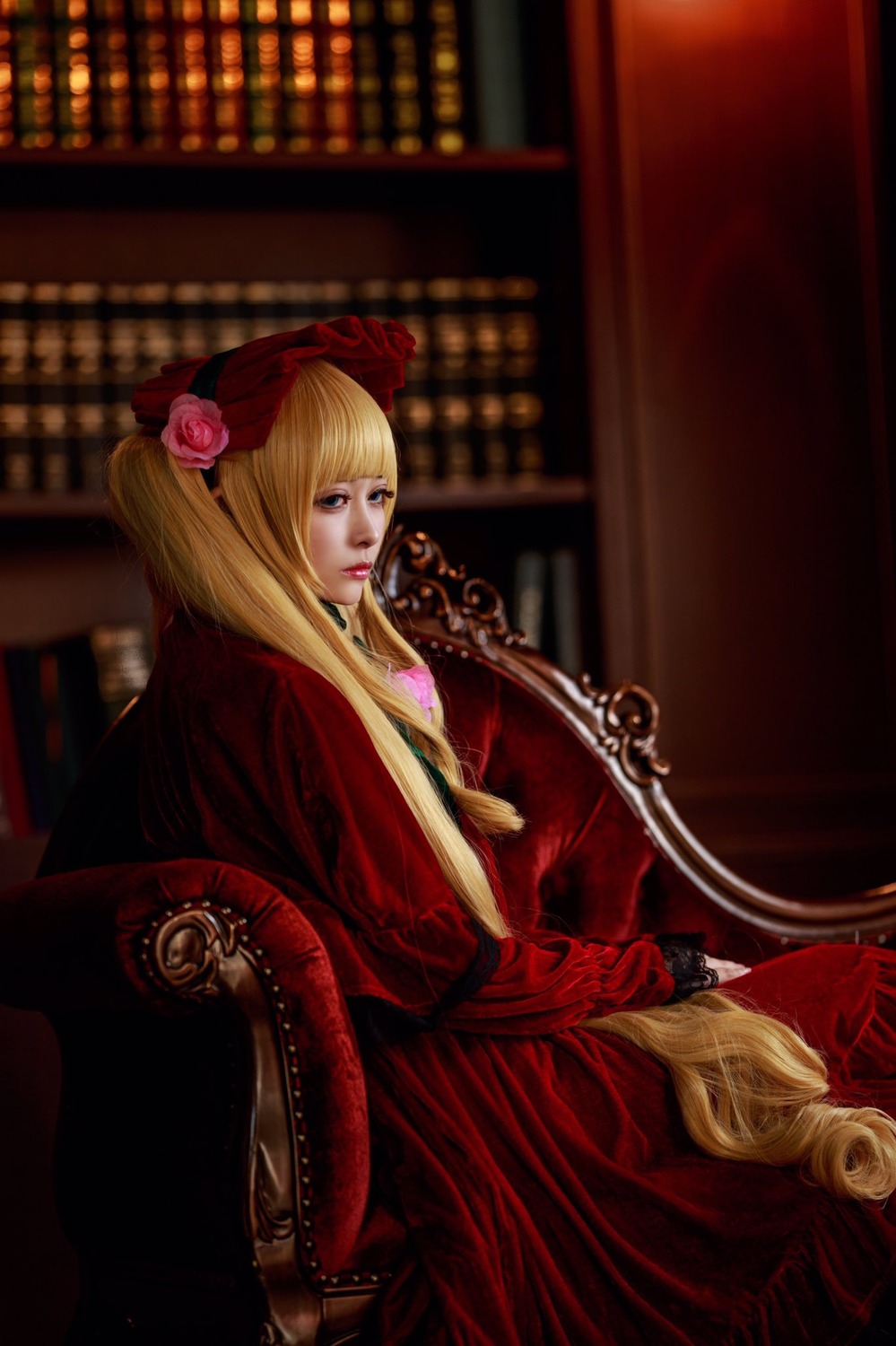 1girl blonde_hair blurry bookshelf depth_of_field dress flower indoors lips long_hair red_dress rose shinku sitting solo