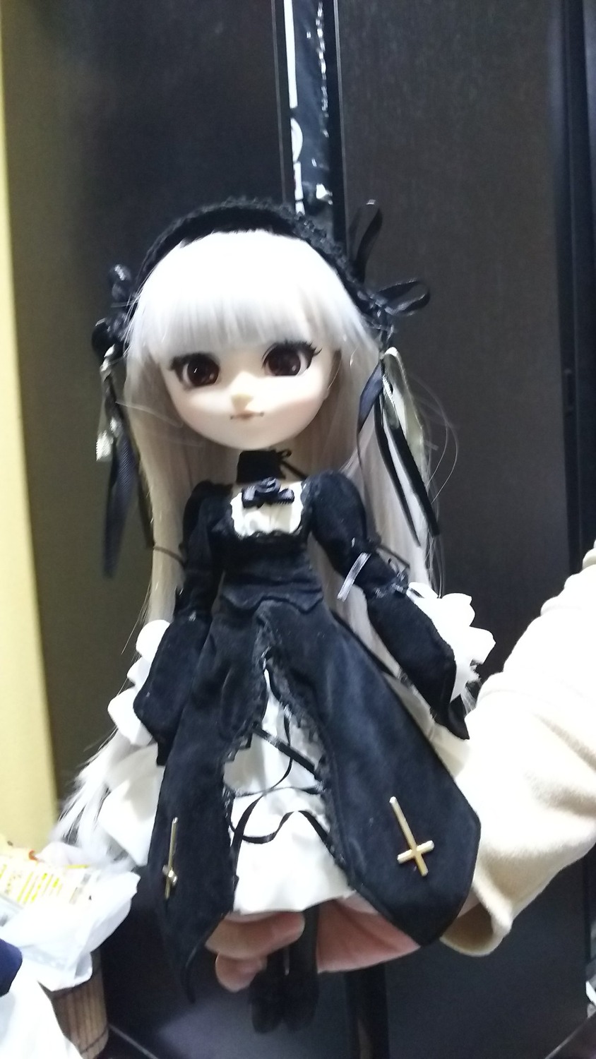 1girl bangs black_dress black_ribbon doll dress expressionless long_hair long_sleeves looking_at_viewer photo ribbon solo standing suigintou white_hair wings