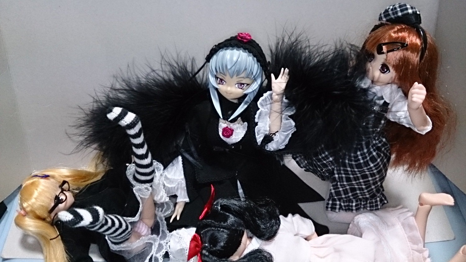 3girls blonde_hair blue_hair brown_hair doll dress eyepatch frills glasses gothic_lolita hairband lolita_fashion long_hair long_sleeves multiple_girls rose sitting solo striped striped_legwear suigintou twintails wings