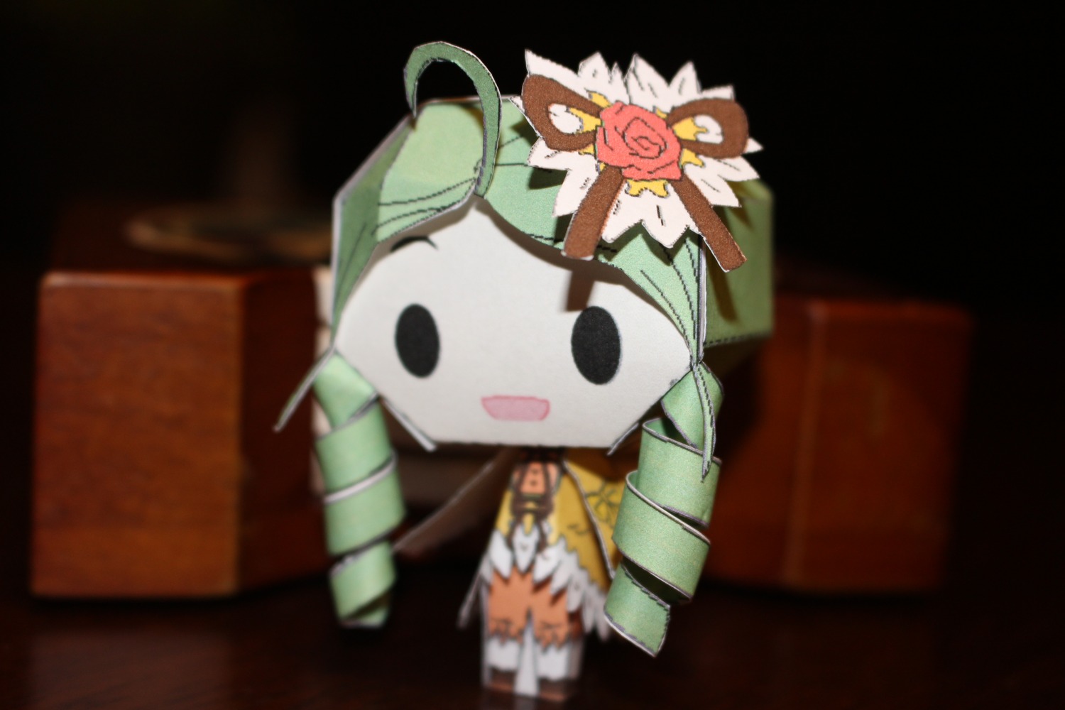 1girl :d ahoge black_eyes blurry blurry_foreground chibi depth_of_field doll flower green_hair kanaria open_mouth solo