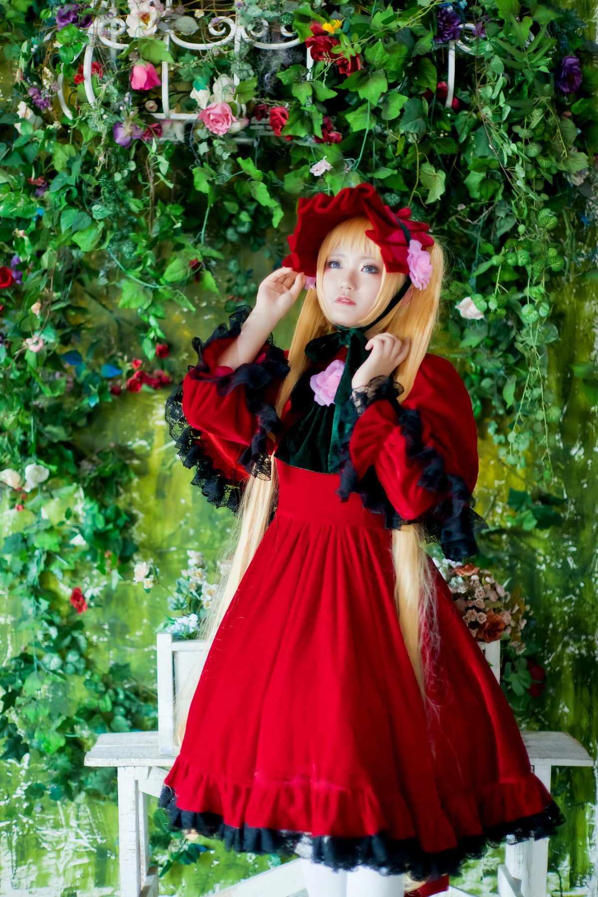 1girl blonde_hair blue_eyes bonnet bush dress flower frills garden long_hair long_sleeves nature outdoors plant red_dress rose shinku solo standing