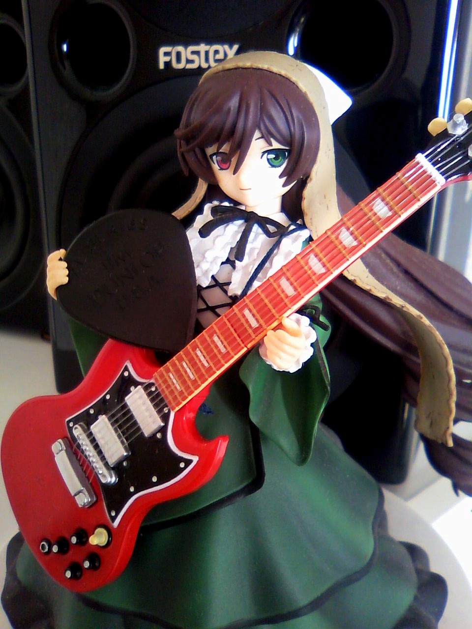1girl bass_guitar brown_hair doll dress electric_guitar frills green_eyes guitar heterochromia instrument long_hair long_sleeves looking_at_viewer plectrum red_eyes solo suiseiseki