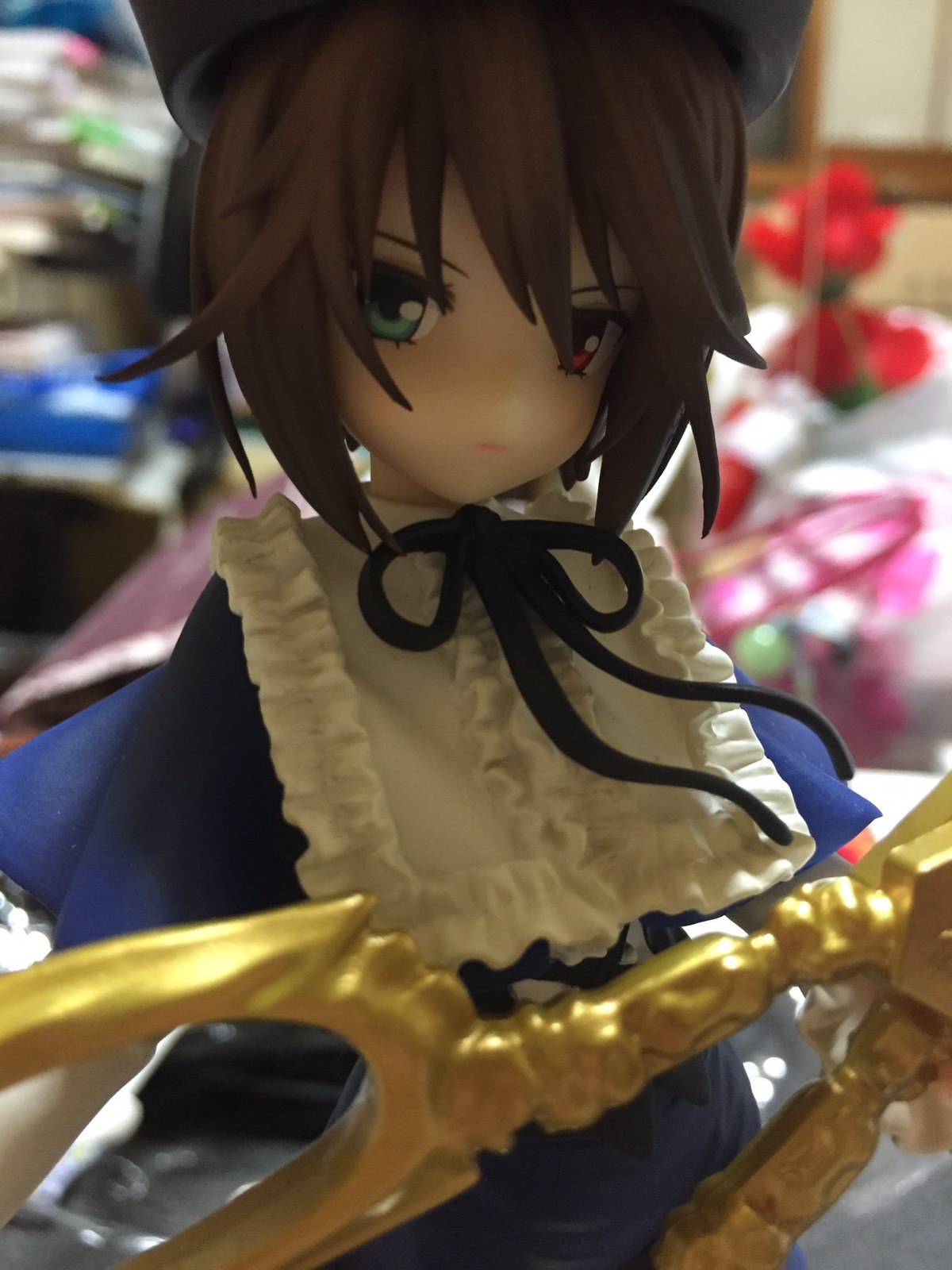 1girl bangs blurry blurry_background blurry_foreground brown_hair closed_mouth depth_of_field doll dress flower frills hat heterochromia long_sleeves looking_at_viewer red_eyes short_hair solo souseiseki