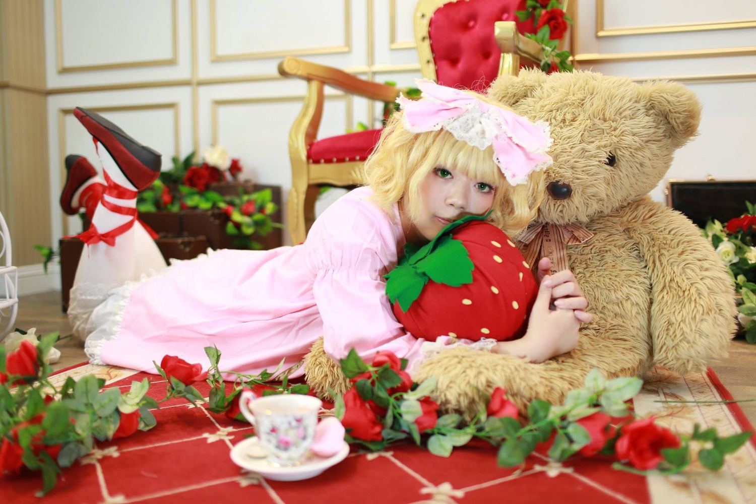 1girl blonde_hair blurry blurry_foreground cake depth_of_field flower food green_eyes hinaichigo red_flower rose solo strawberry stuffed_animal