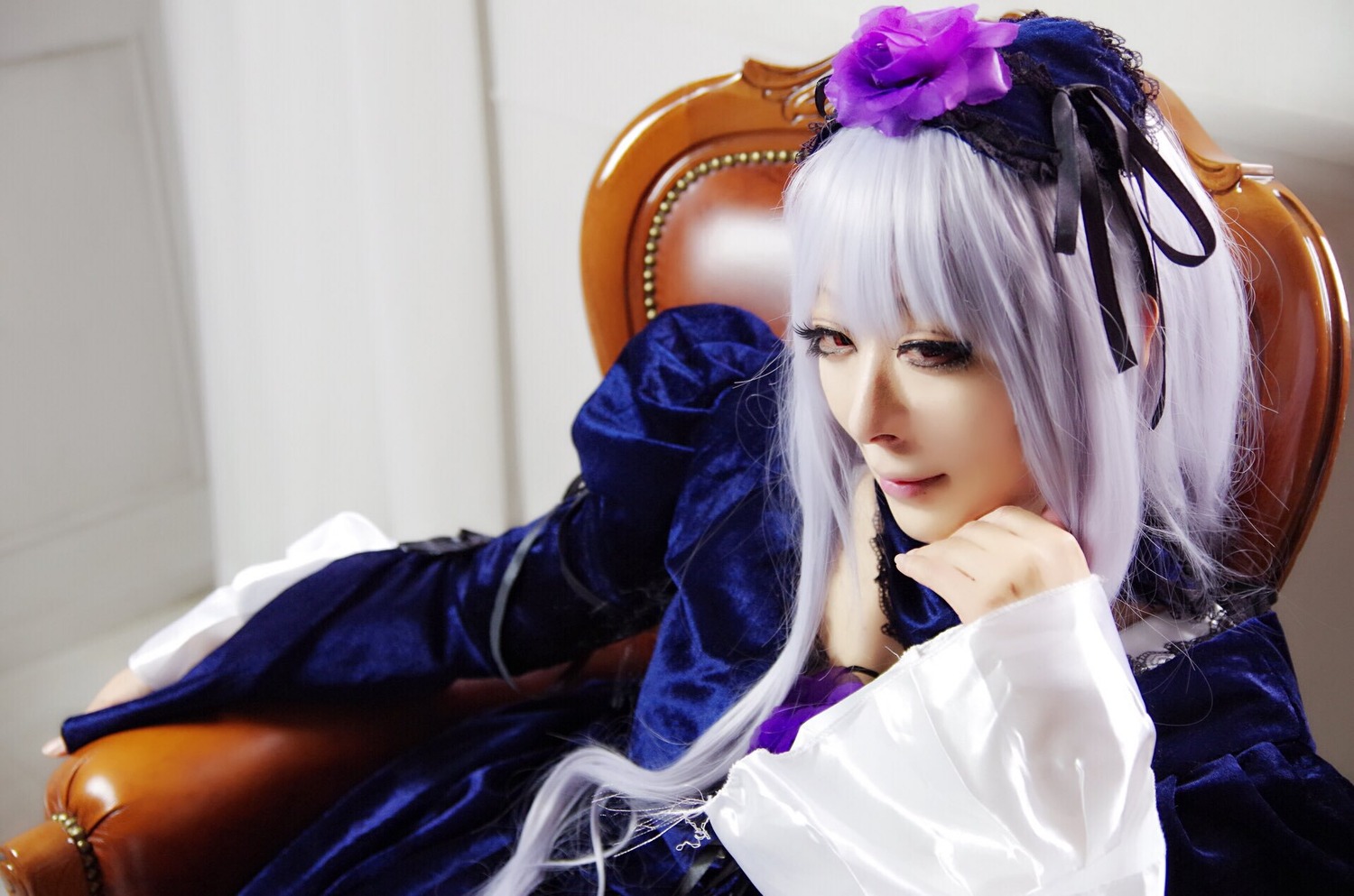 1girl chin_rest dress flower frills hair_ornament hairband lace lips long_hair long_sleeves lying red_eyes ribbon silver_hair solo suigintou