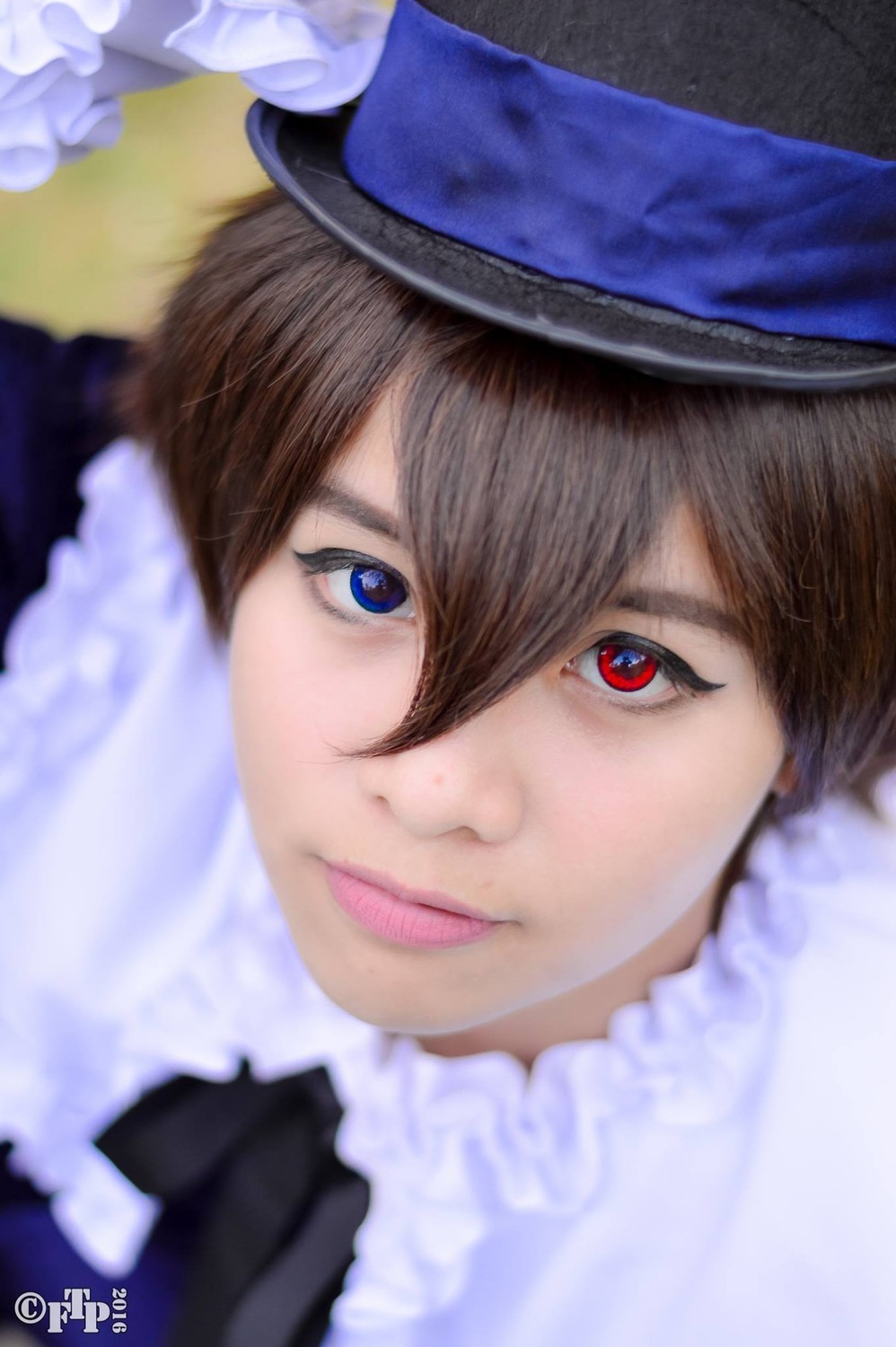 1boy black_gloves blue_eyes blue_headwear blurry blurry_foreground brown_hair depth_of_field face gloves hair_between_eyes hat heterochromia lips looking_at_viewer red_eyes smile solo souseiseki