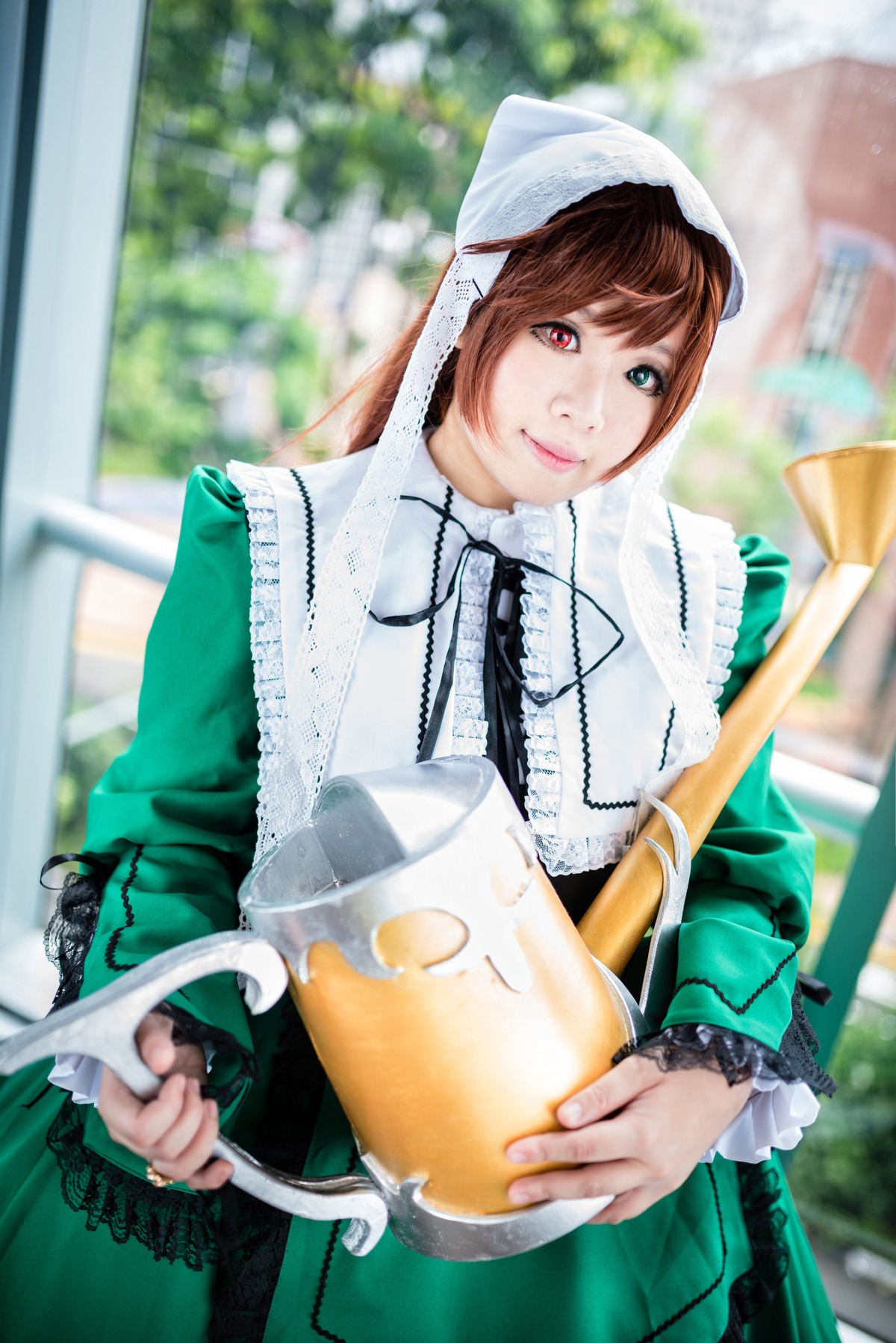1girl 3d blurry blurry_background brown_hair depth_of_field dress frills green_dress green_eyes heterochromia lips long_hair long_sleeves looking_at_viewer outdoors red_eyes smile solo suiseiseki watering_can