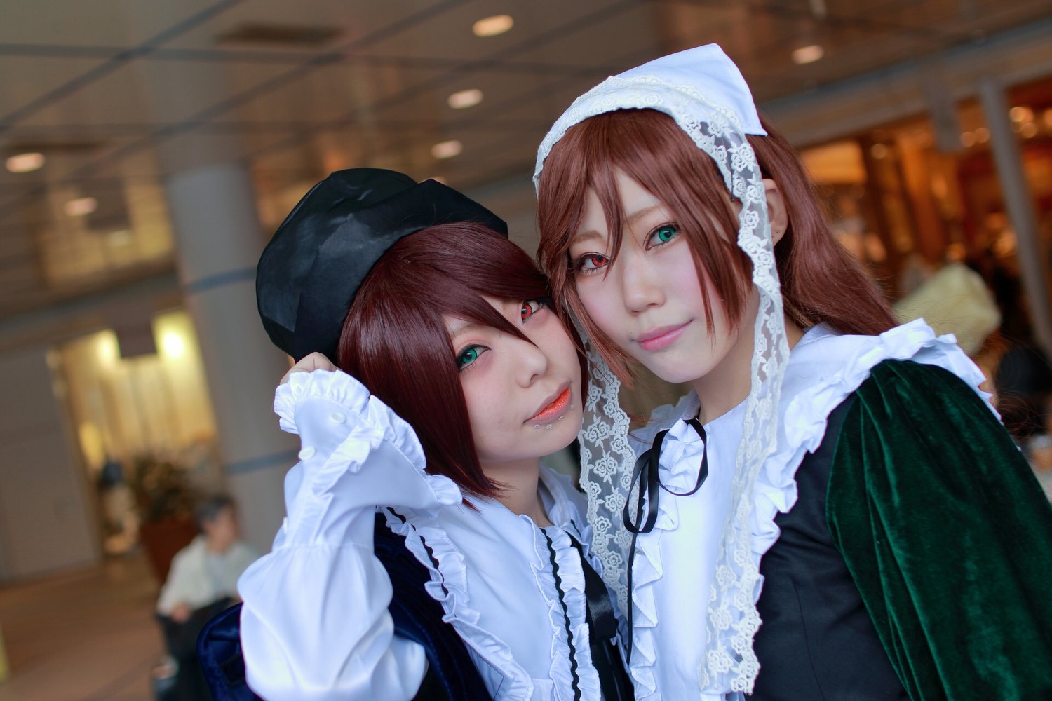 2girls blurry blurry_background brown_hair depth_of_field green_eyes hat head_scarf heterochromia indoors lips long_hair looking_at_viewer multiple_cosplay multiple_girls red_eyes siblings sisters smile souseiseki suiseiseki tagme twins
