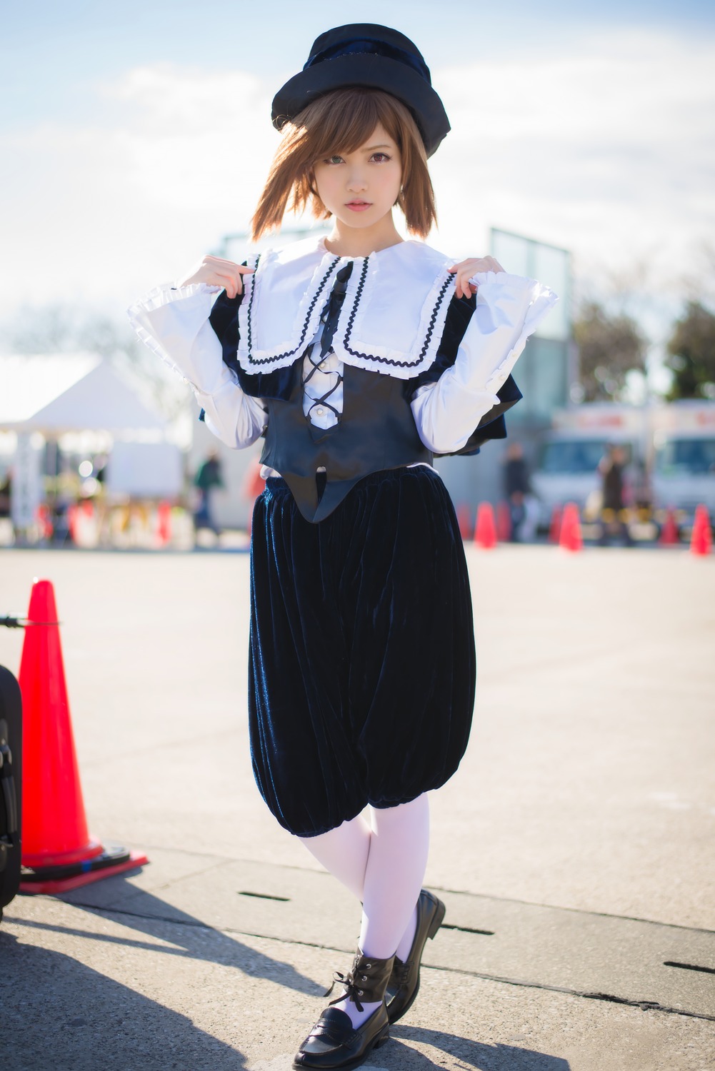 1girl black_footwear blurry blurry_background blurry_foreground brown_eyes brown_hair capelet depth_of_field full_body hat lips long_sleeves looking_at_viewer outdoors shoes short_hair skirt solo souseiseki standing white_legwear