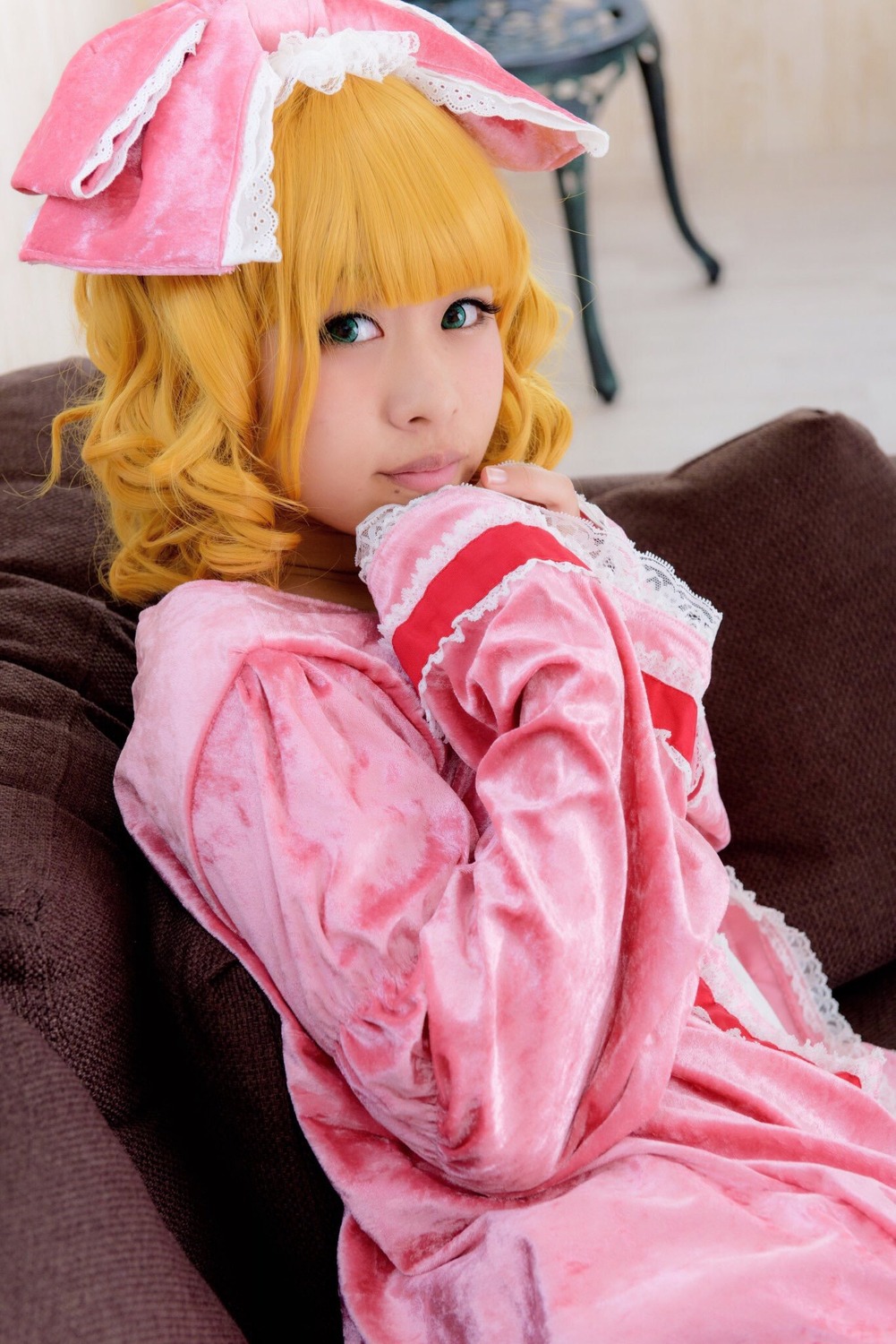 1girl bangs blonde_hair blue_eyes blunt_bangs bow dress frills hair_bow hinaichigo lips long_sleeves looking_at_viewer looking_to_the_side photo pillow short_hair sleeves_past_wrists solo traditional_media