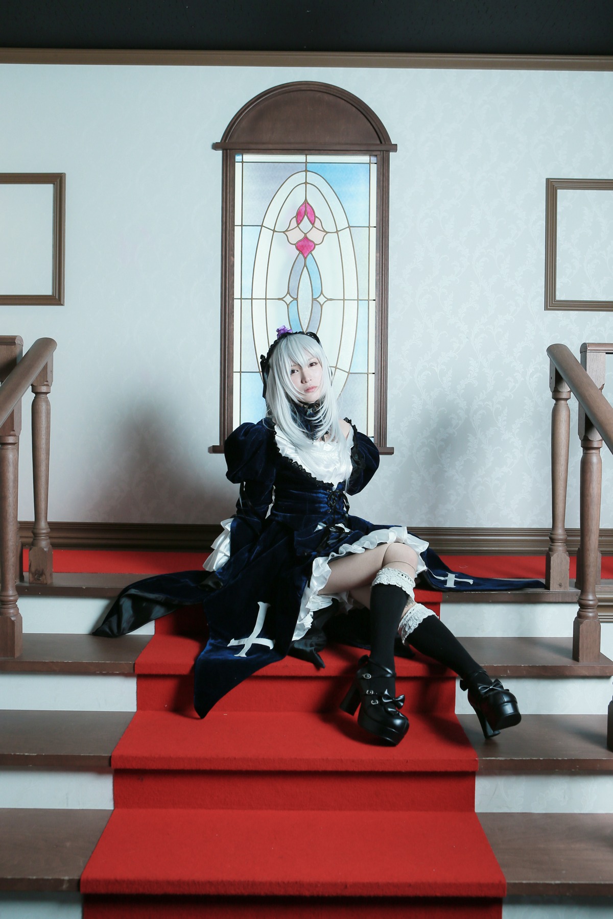 1girl black_footwear black_legwear boots dress frills gothic_lolita hairband indoors lolita_fashion red_eyes silver_hair sitting solo suigintou