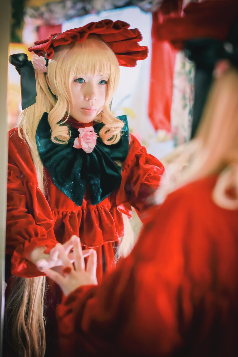1girl blonde_hair blue_eyes blurry blurry_background blurry_foreground bonnet bow depth_of_field dress figure flower long_hair long_sleeves photo red_dress rose shinku solo solo_focus teacup